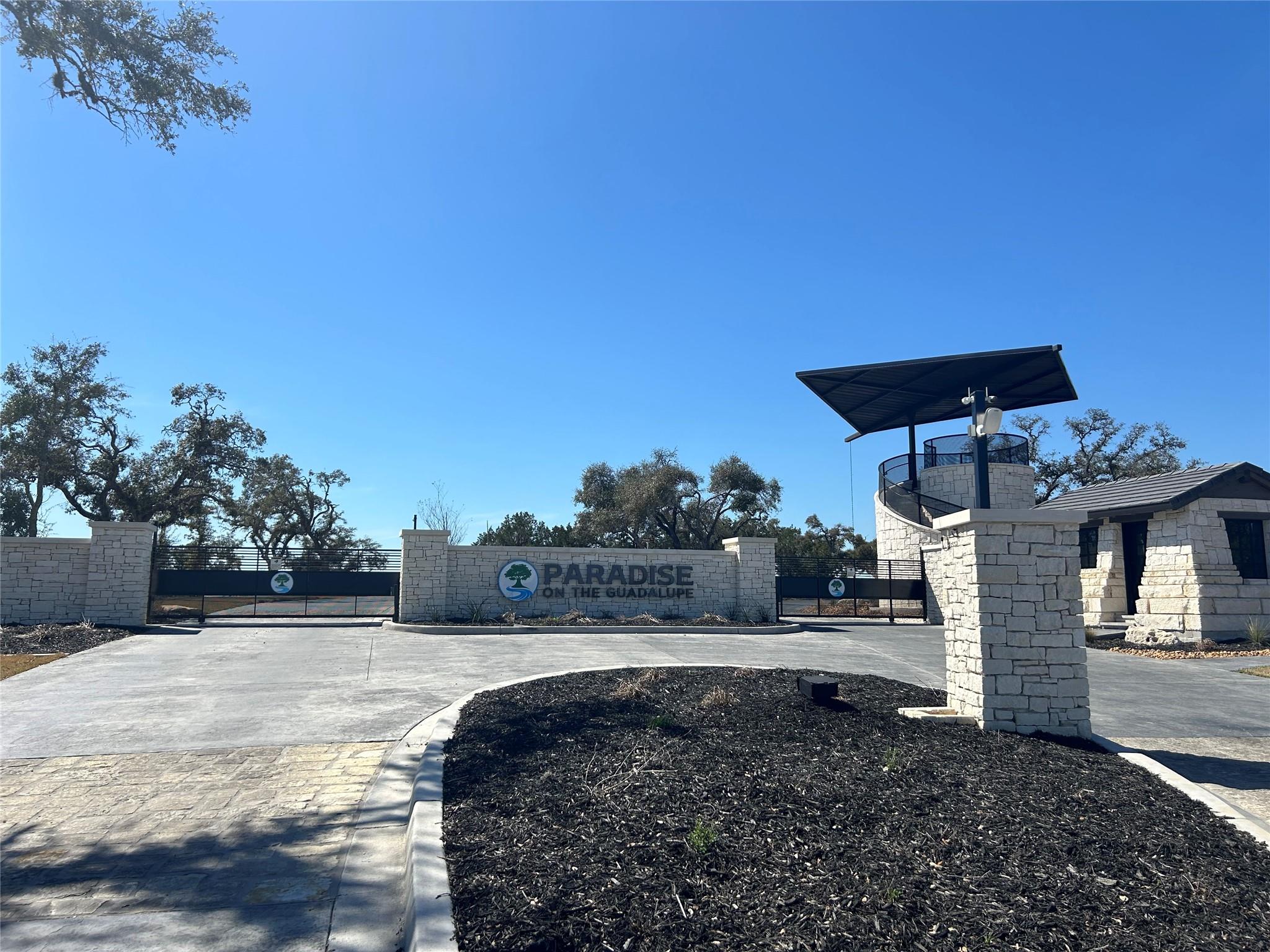 Community sign featuring a gate and fence