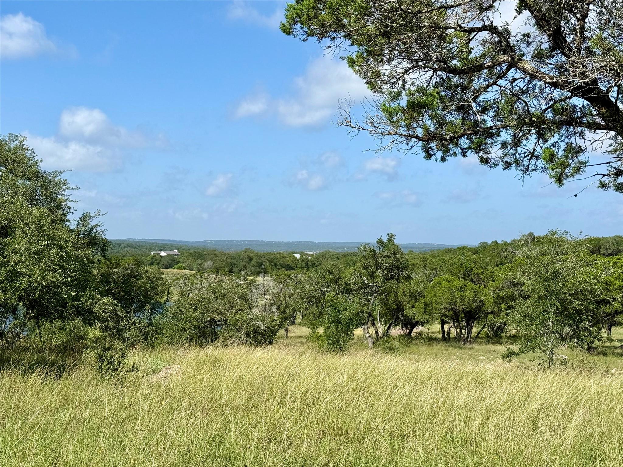 A verdant landscape unfolds under a clear sky, of
