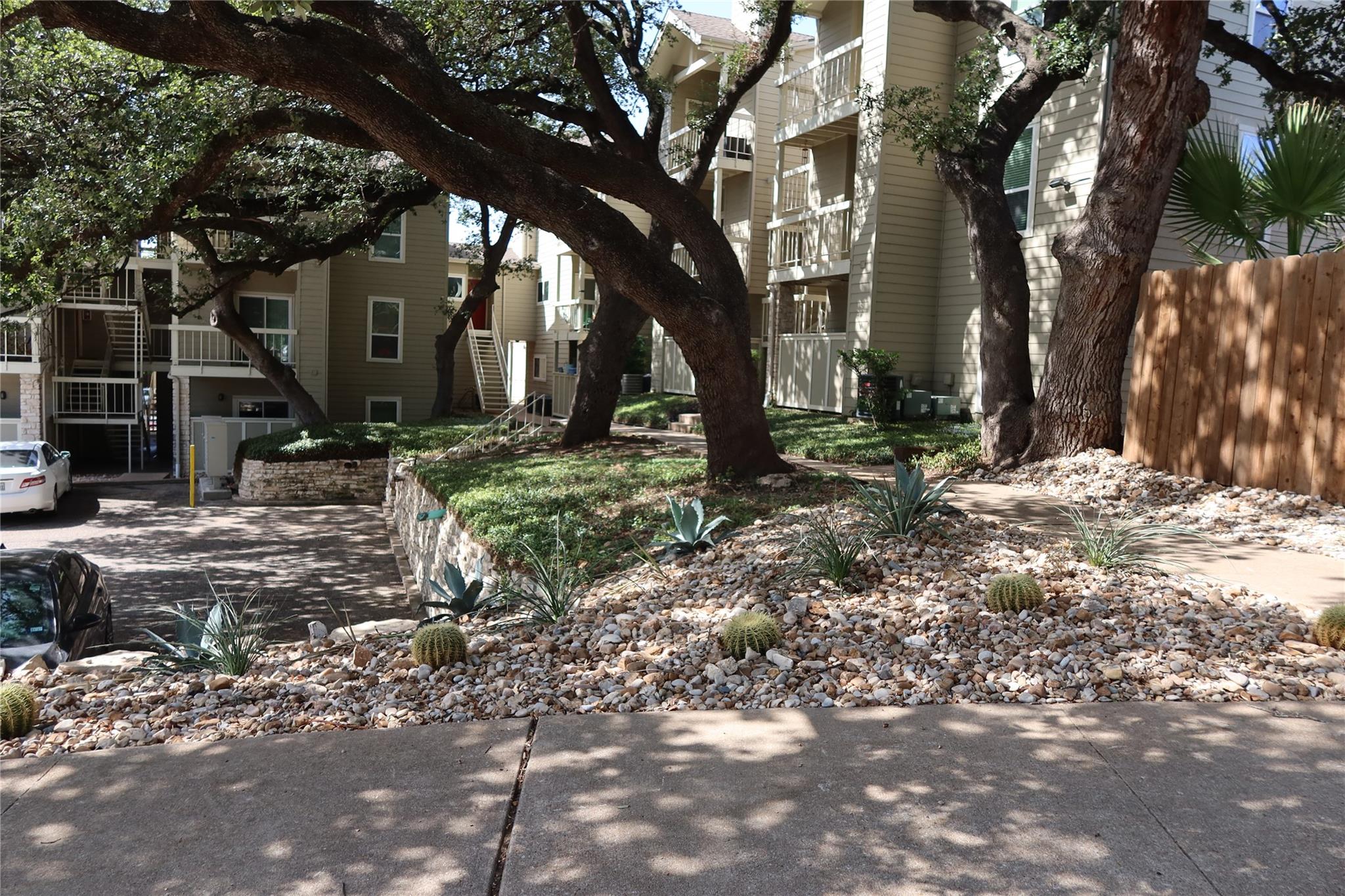 Mature trees shade the native stone-scaped beds a