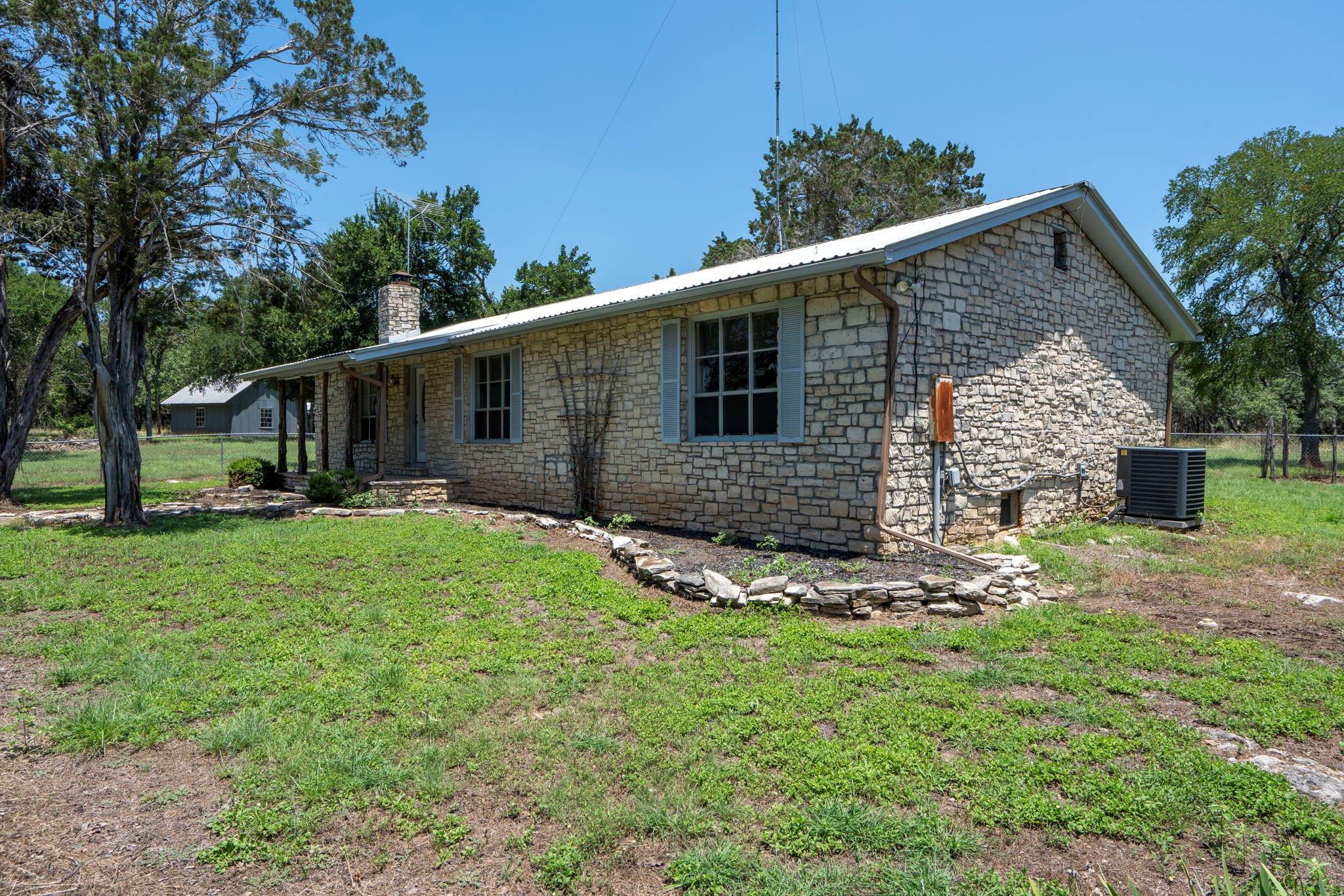 Single story home featuring stone siding, a chimn