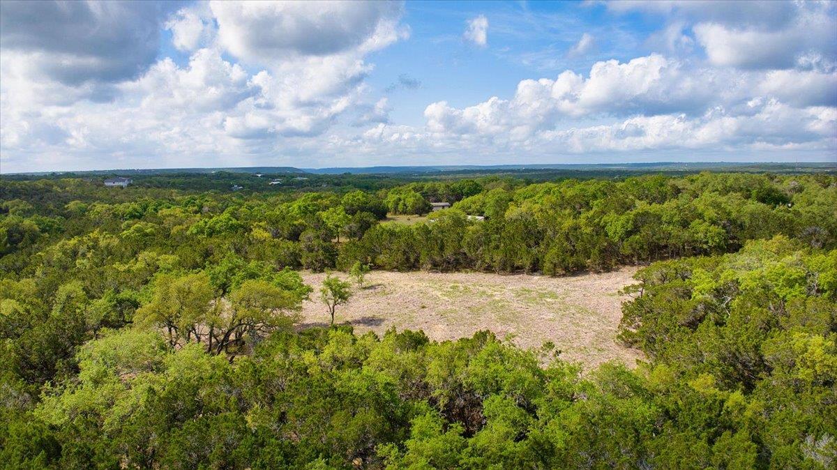 Birds eye view of property featuring a wooded view