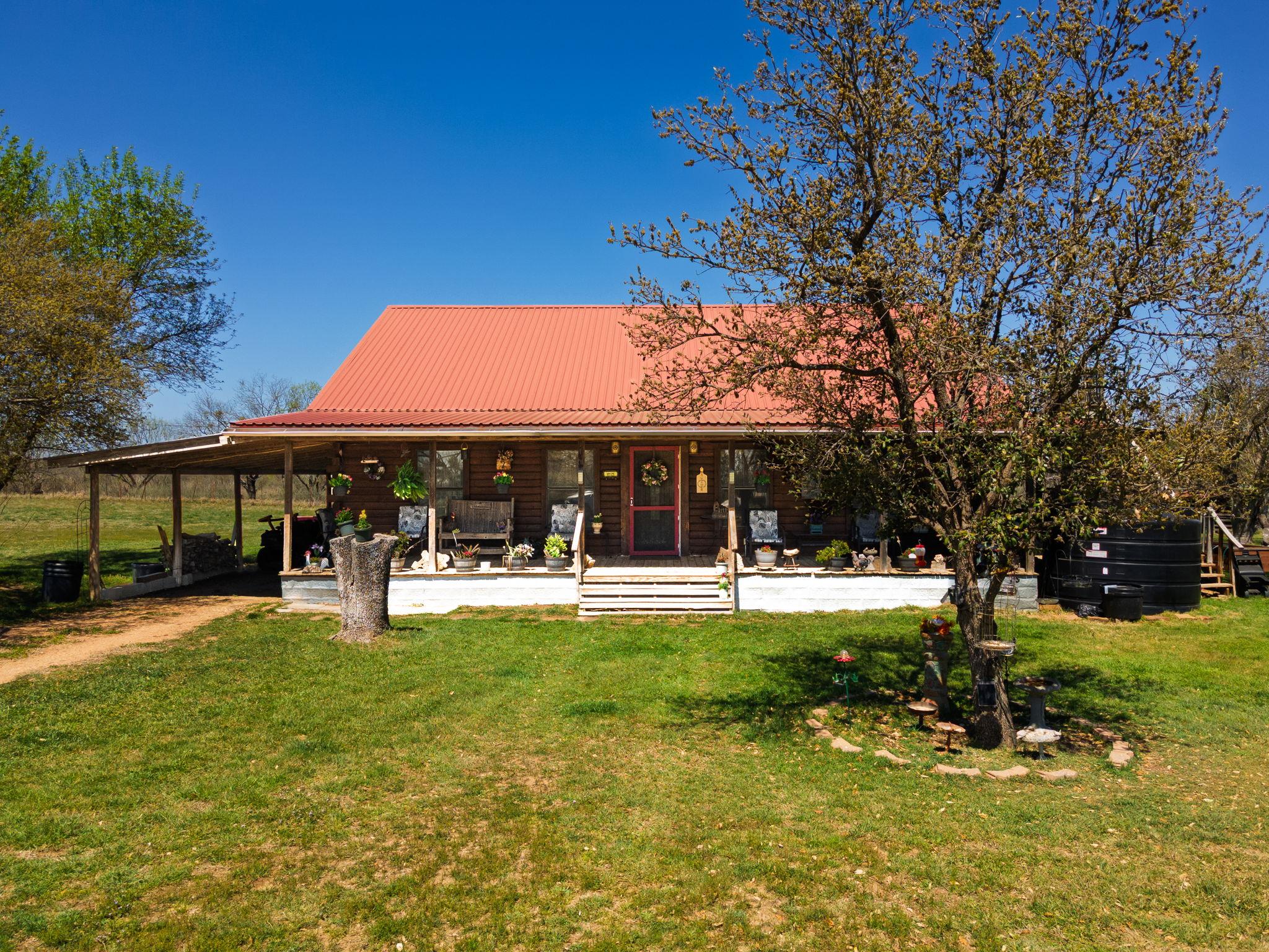 Rear view of house featuring covered porch, a law