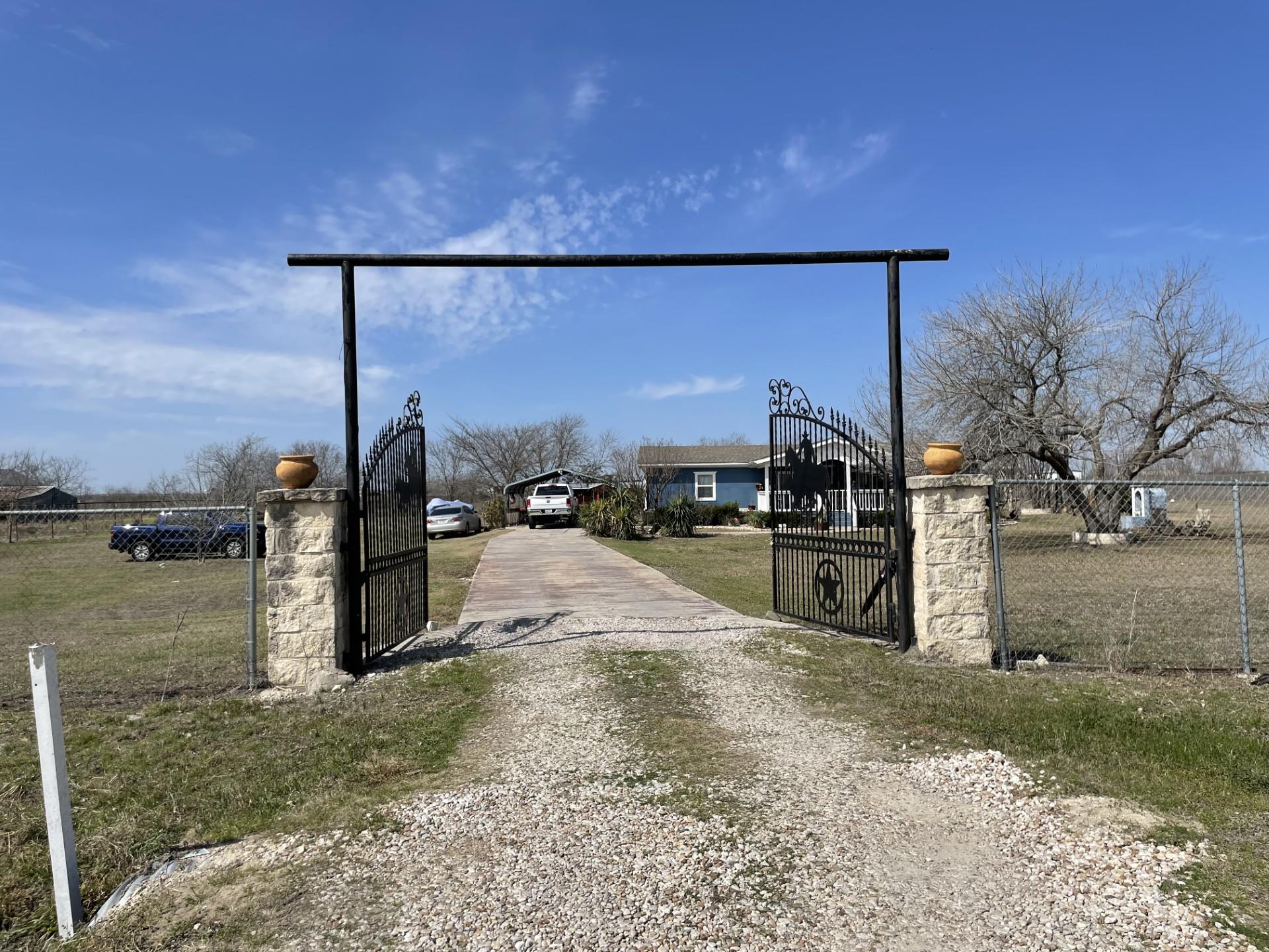 View of road featuring a gated entry, driveway, a