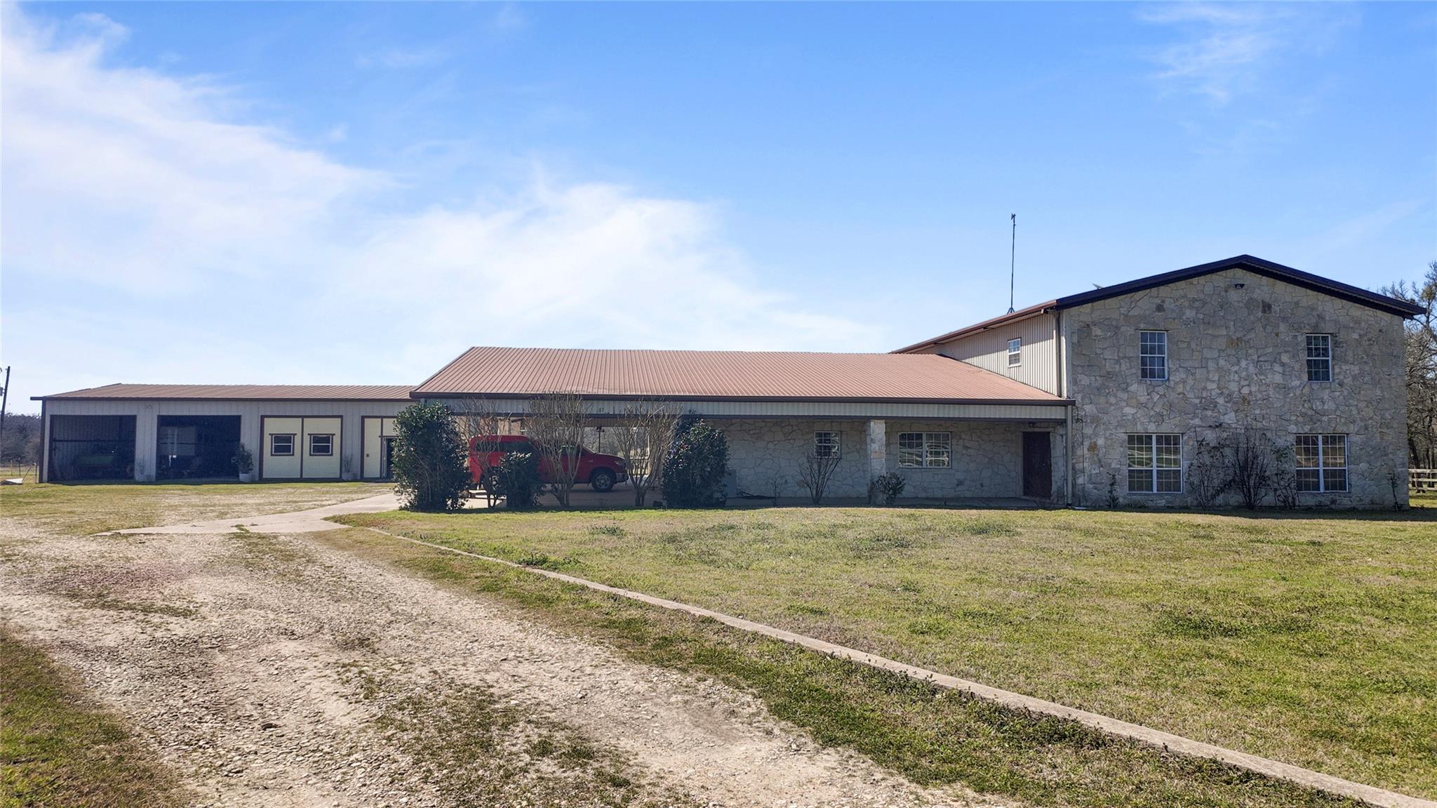 View of front facade featuring dirt driveway, sto
