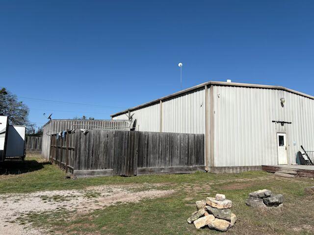 View of outbuilding with fence