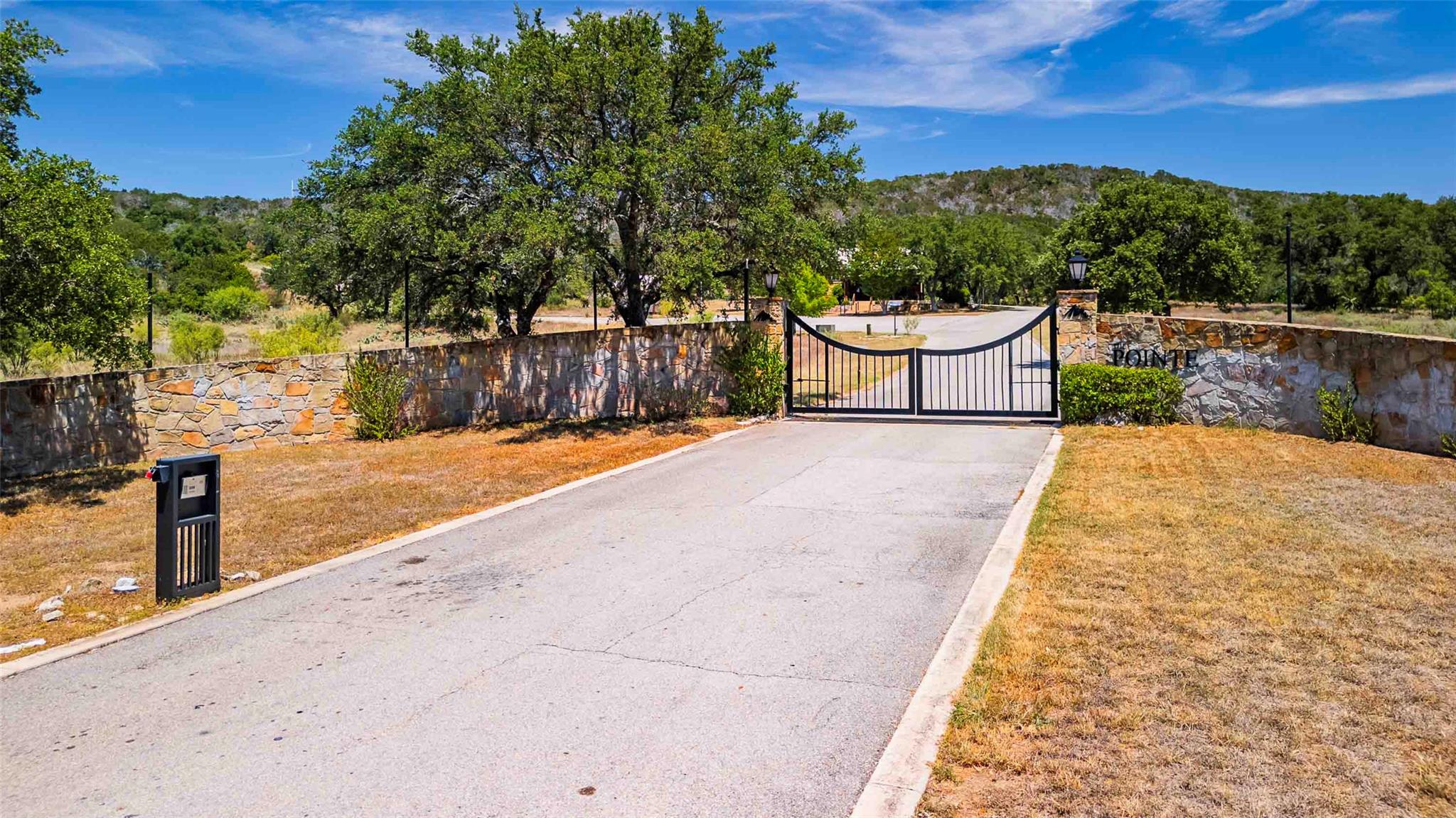 View of road with curbs, a gated entry, and a gate