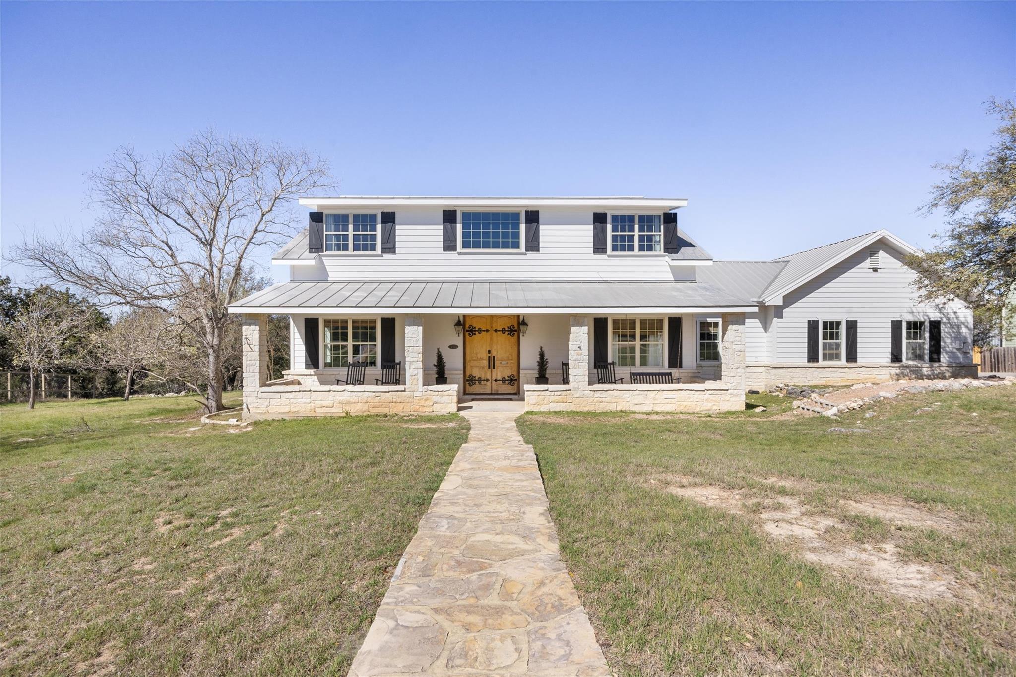 View of front of home with stone siding, a porch,