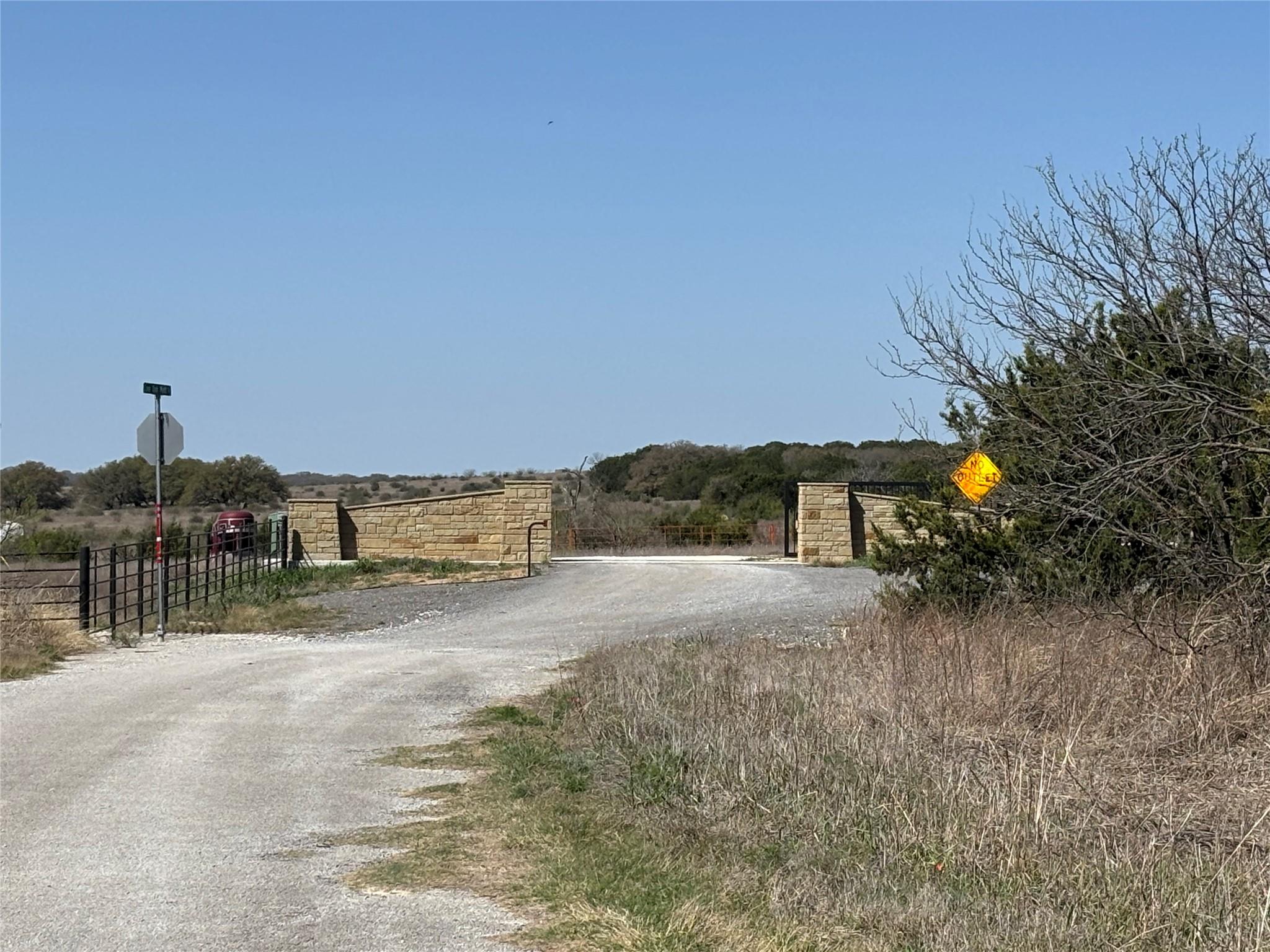 View of road with a gate, traffic signs, and a ru
