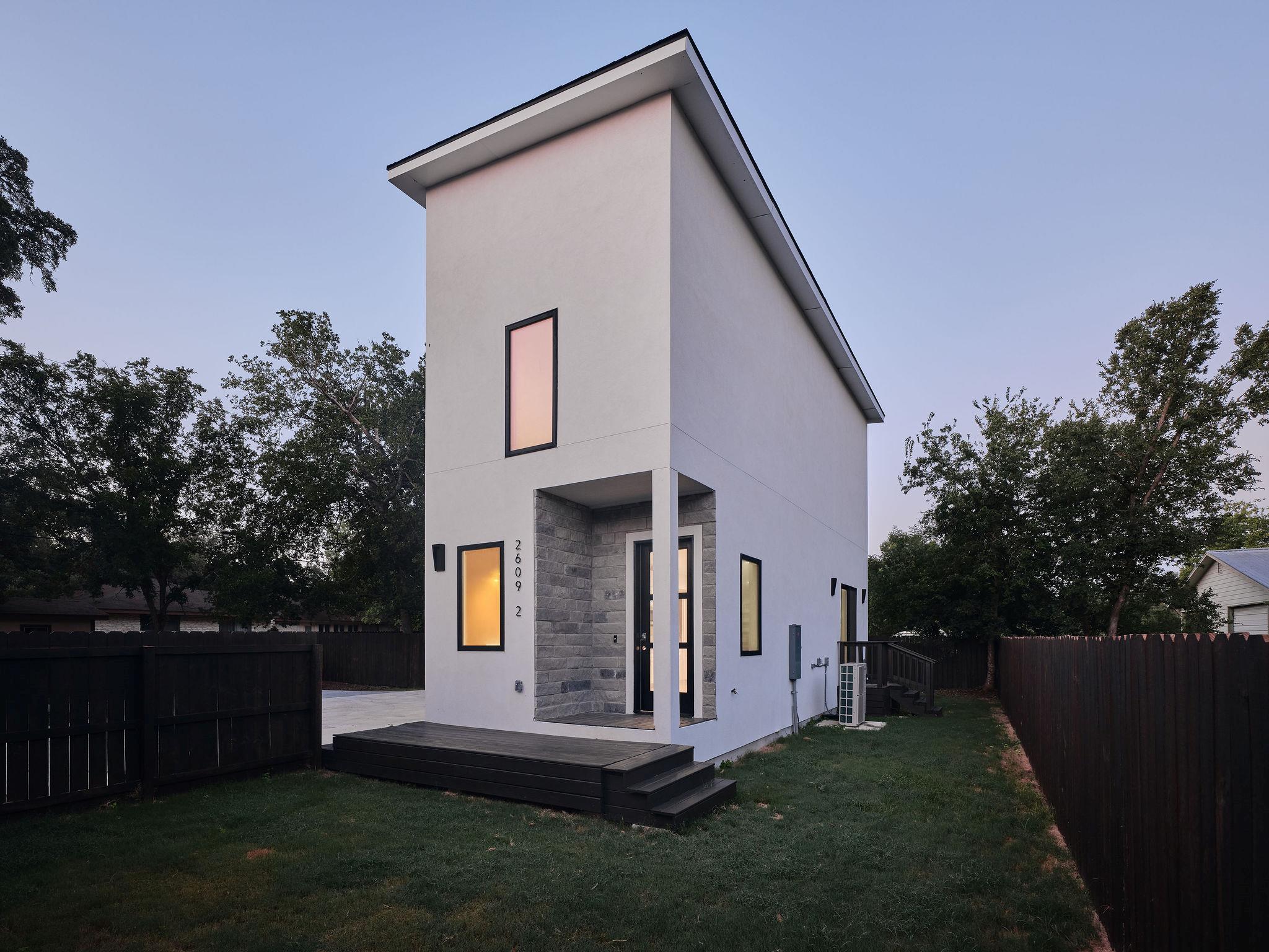 Back of property at dusk with stone siding, a fen