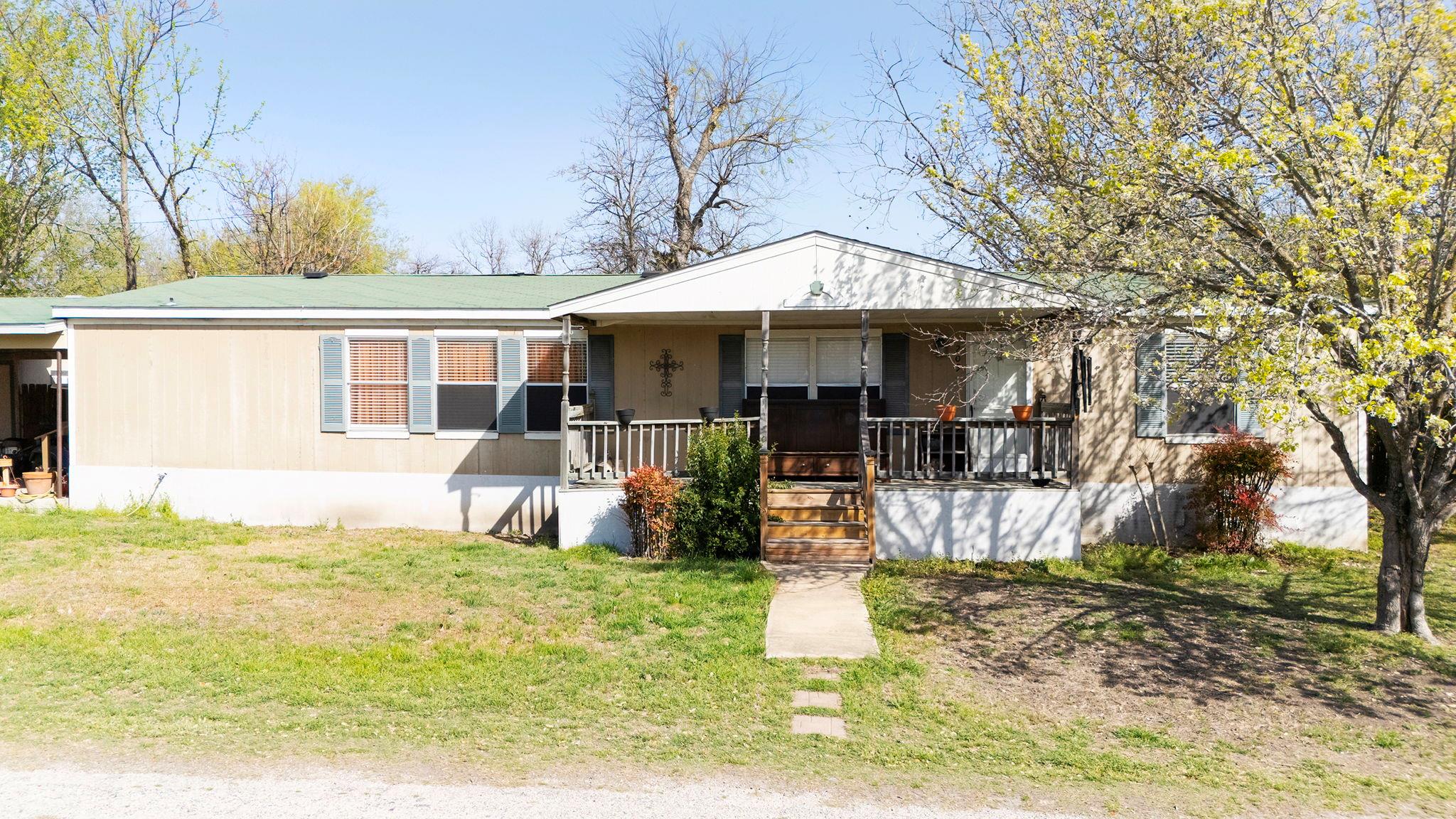 View of front of home with a front yard and a por