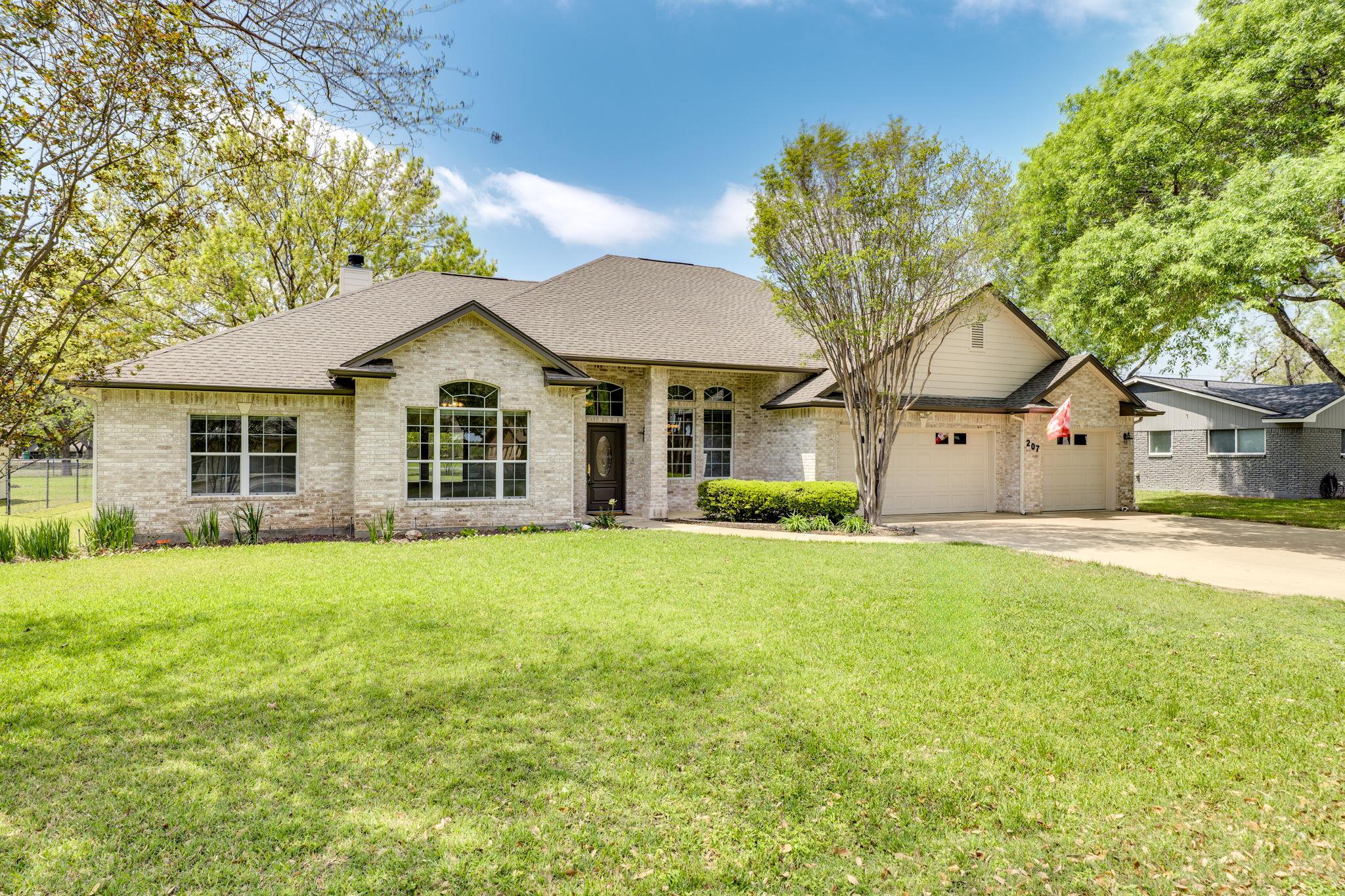 Single story home with driveway, brick siding, a 