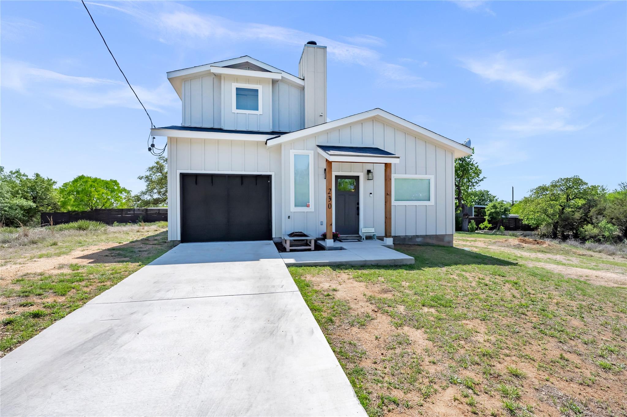 Modern farmhouse with an attached garage, a chimn