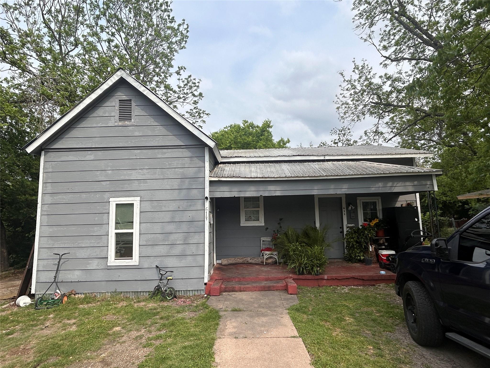 View of front of house featuring a porch and meta
