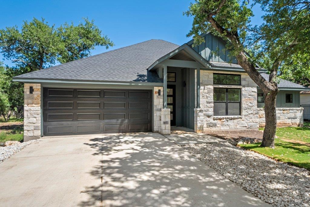 Single story home with a shingled roof, board and