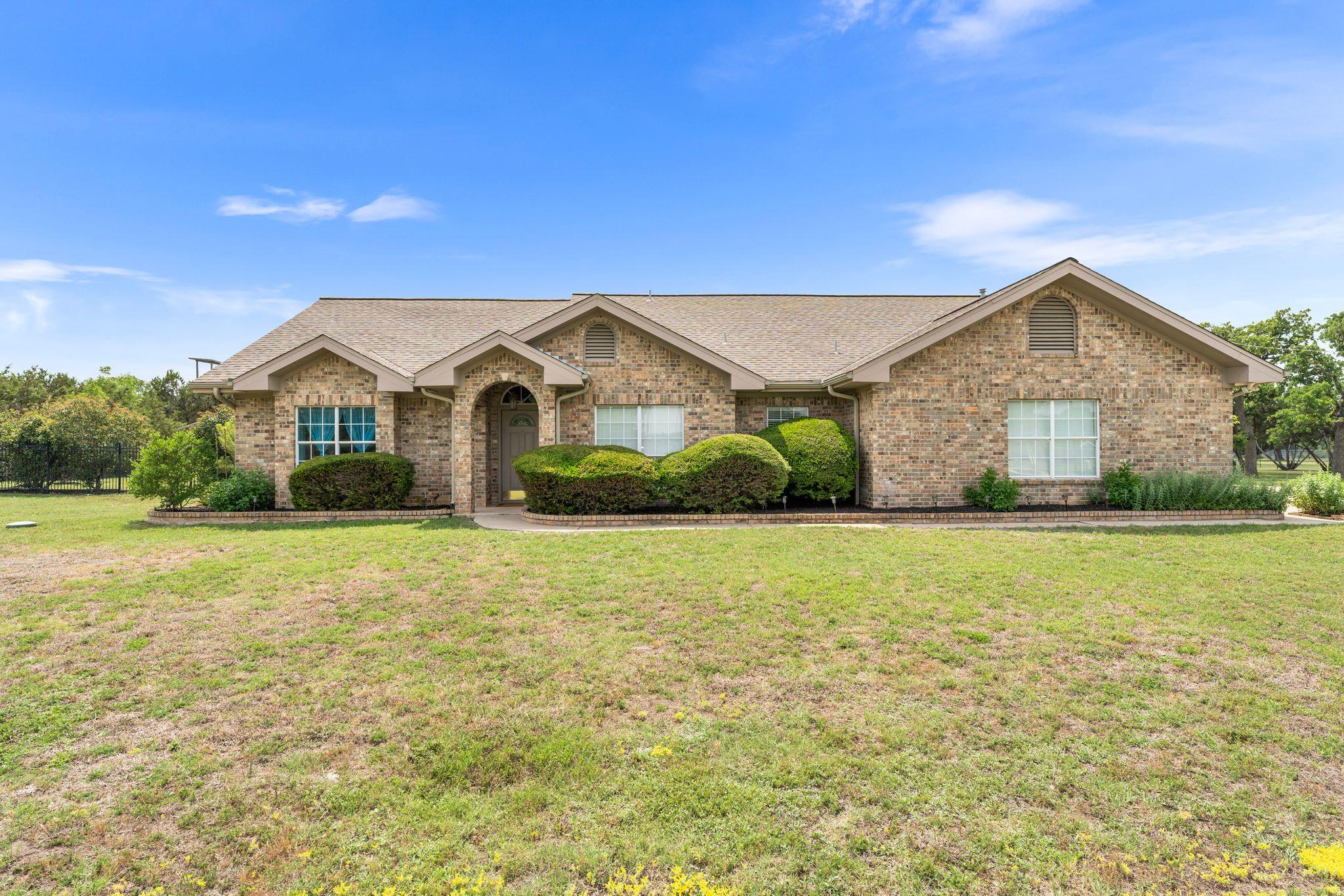 Ranch-style home with roof with shingles, a front