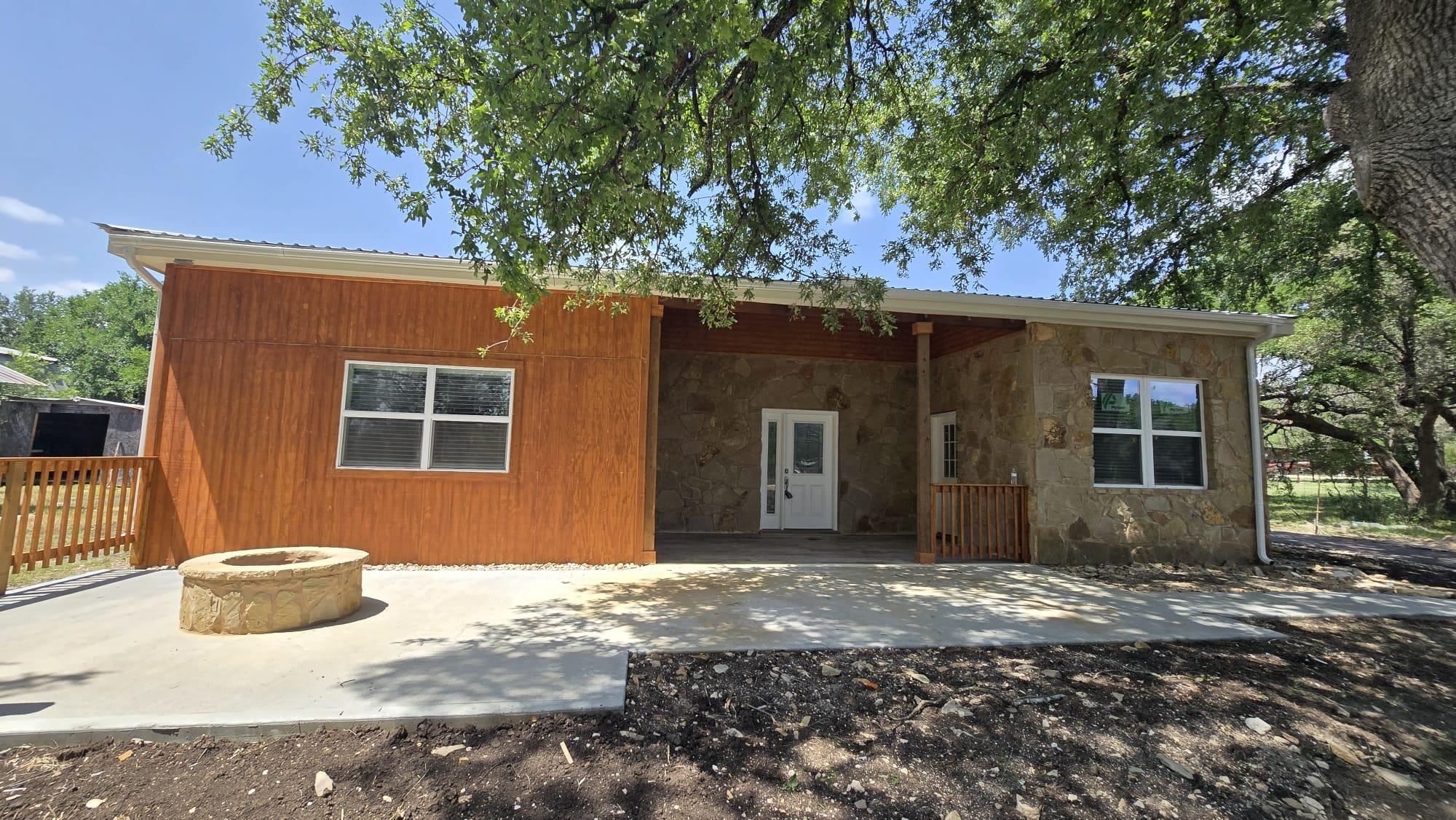 Rear view of house featuring an outdoor fire pit,