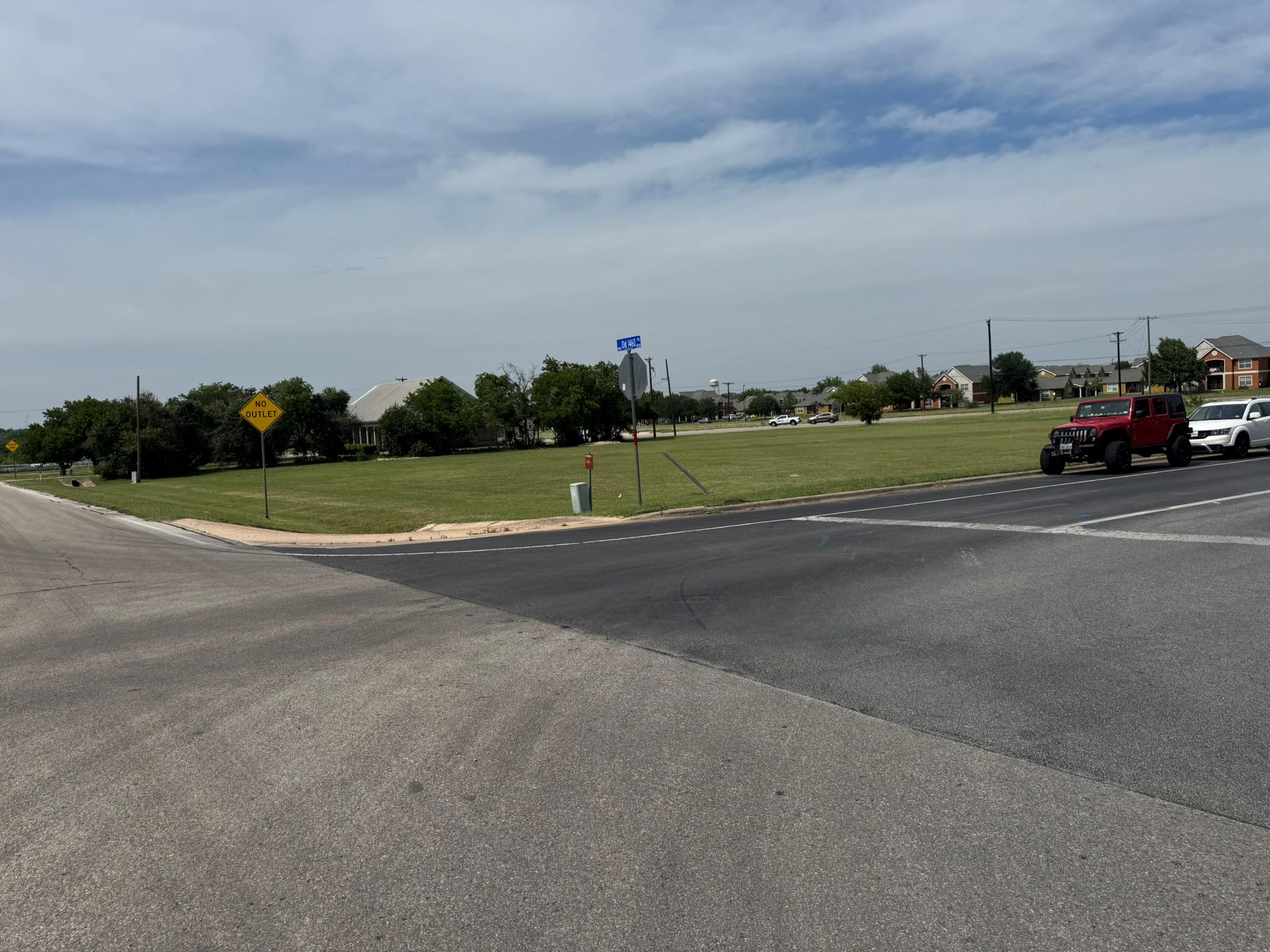 View of asphalt road featuring traffic signs and 