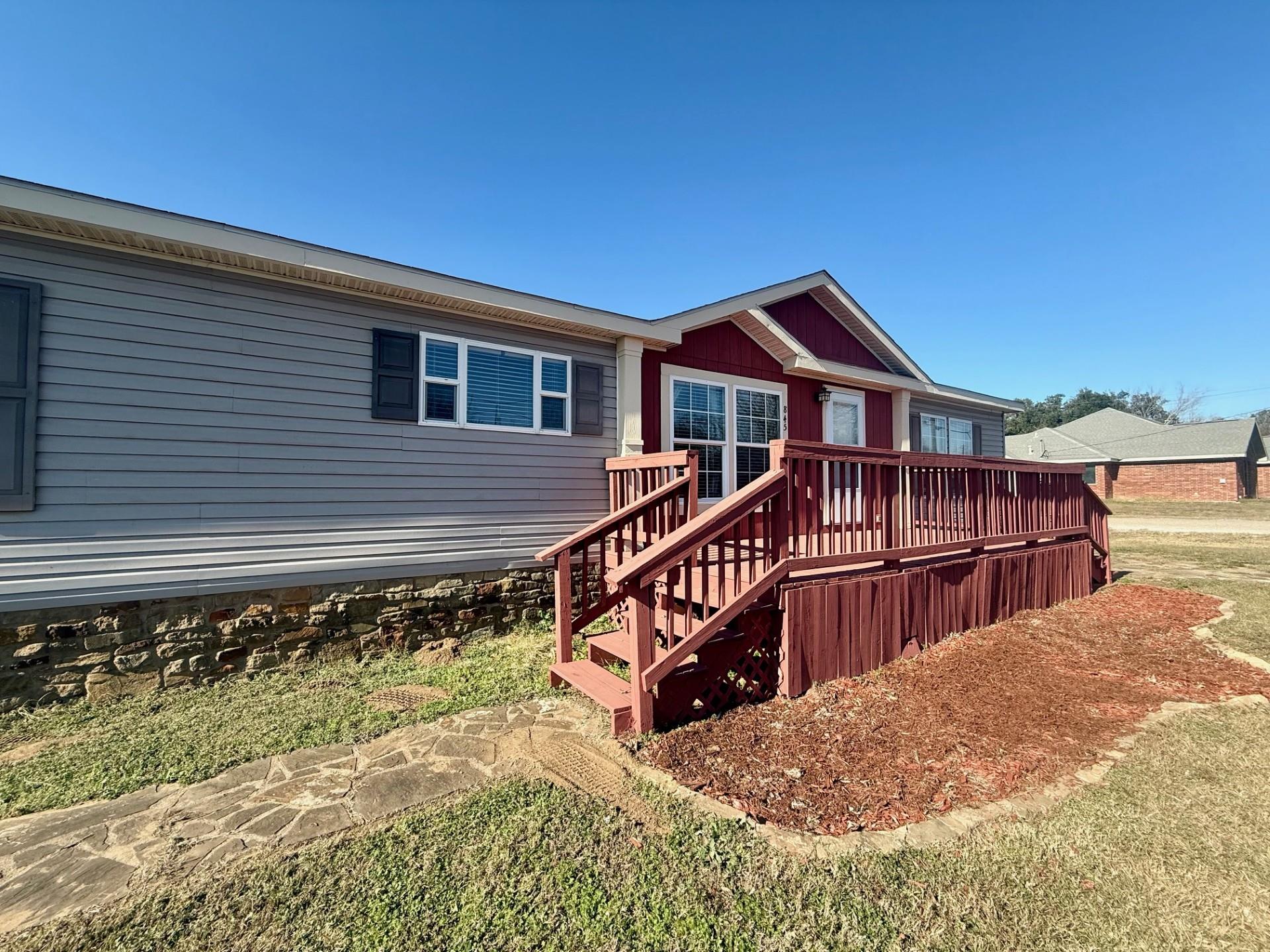 Rear view of property with a deck, stairway, and 
