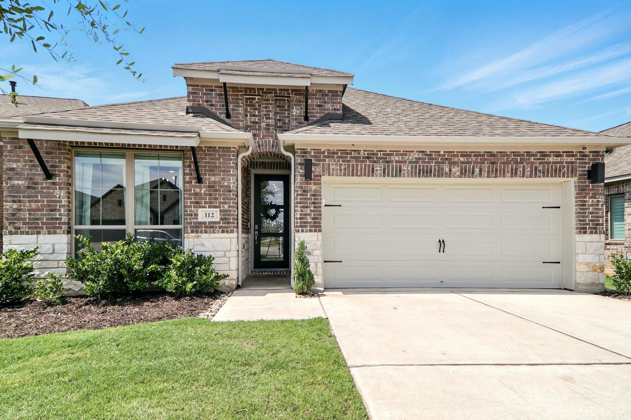 French country home featuring concrete driveway, 