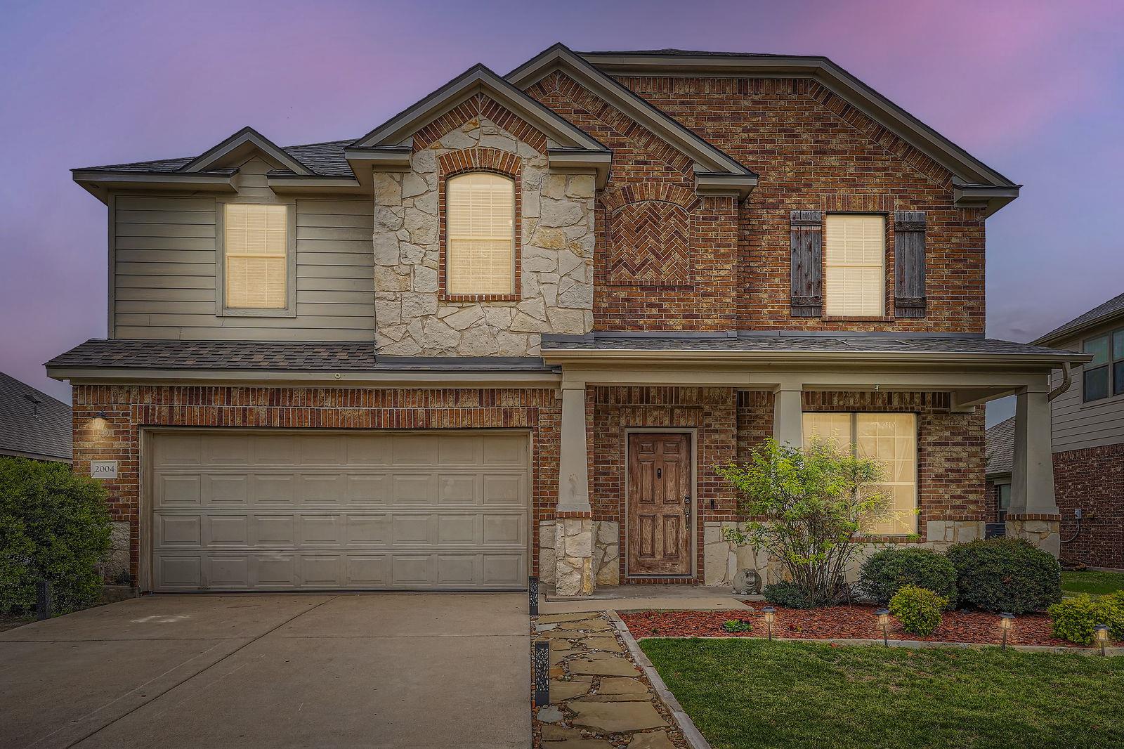 View of front of home with brick siding, concrete