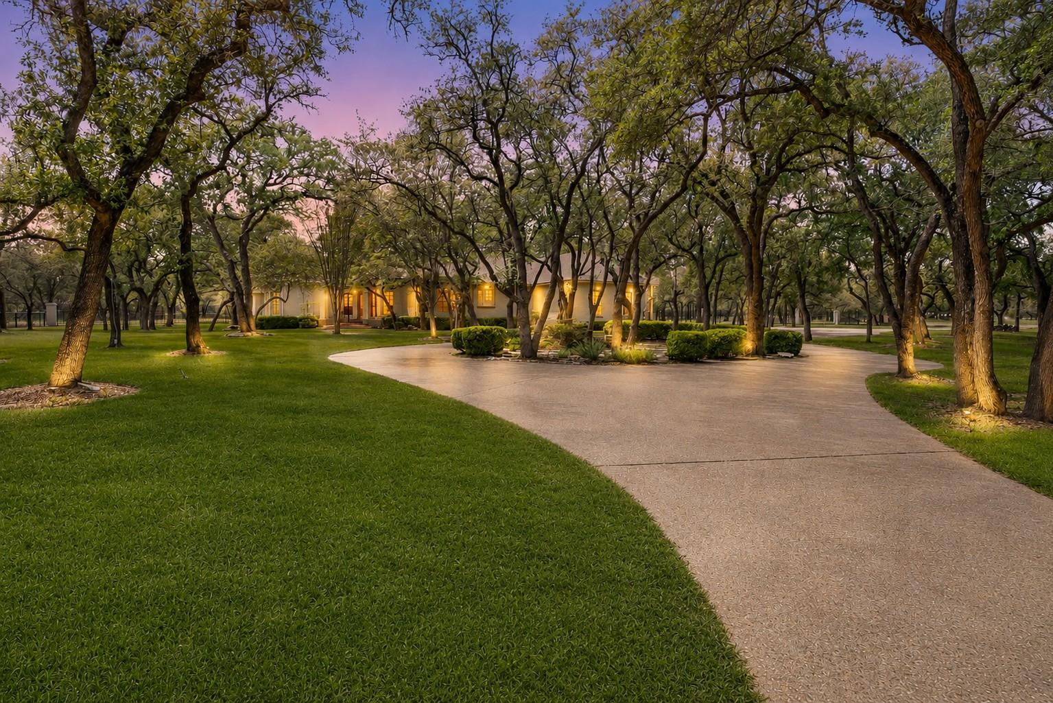 Mature trees and lush landscaping frame the sweep