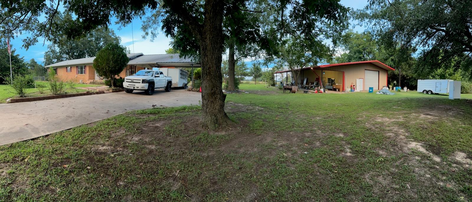 View of grassy yard featuring concrete driveway, 