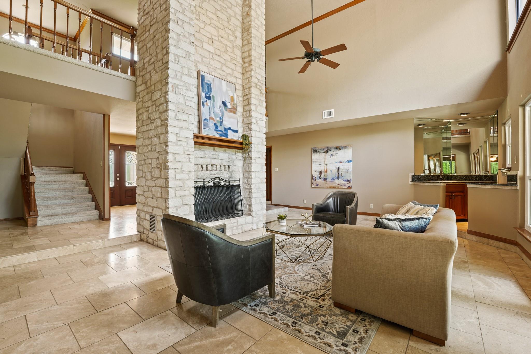 Living area with a towering ceiling, a stone fire