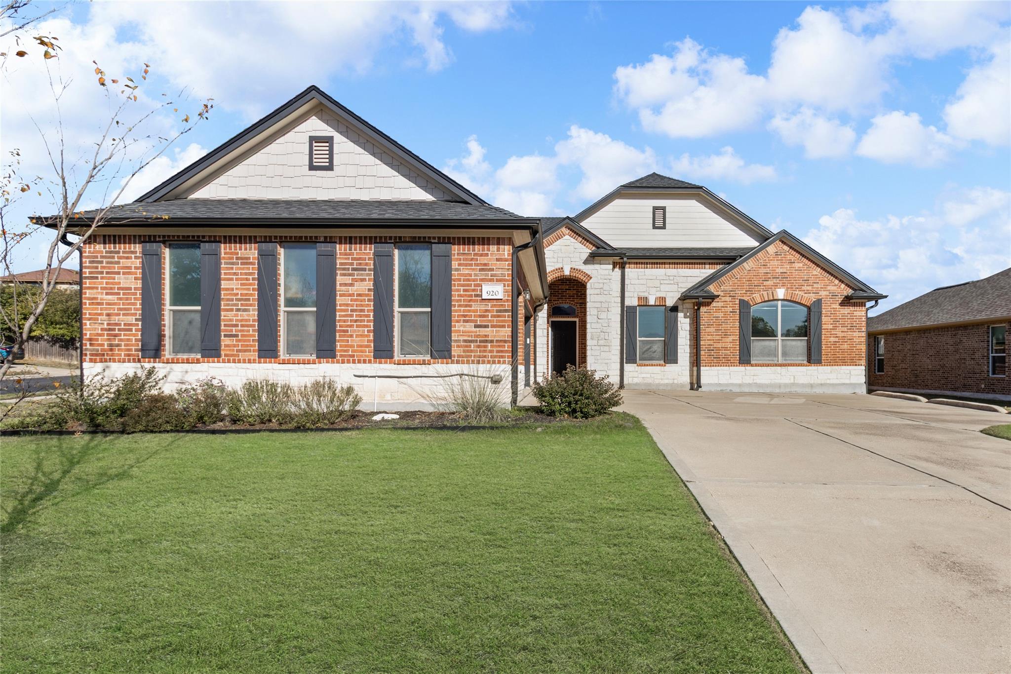 View of front of home with brick siding, a front 