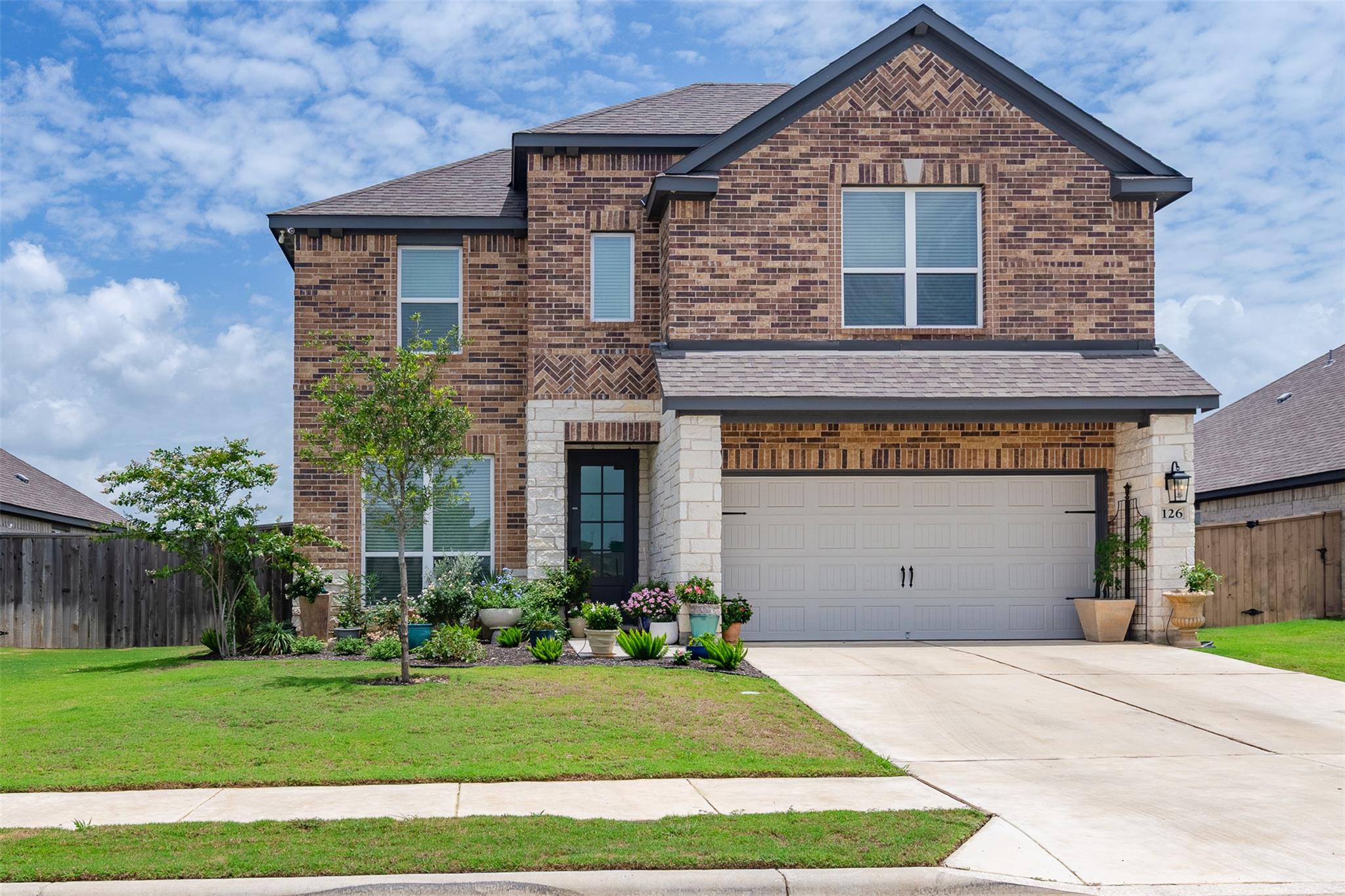 View of front facade featuring brick siding, a ga