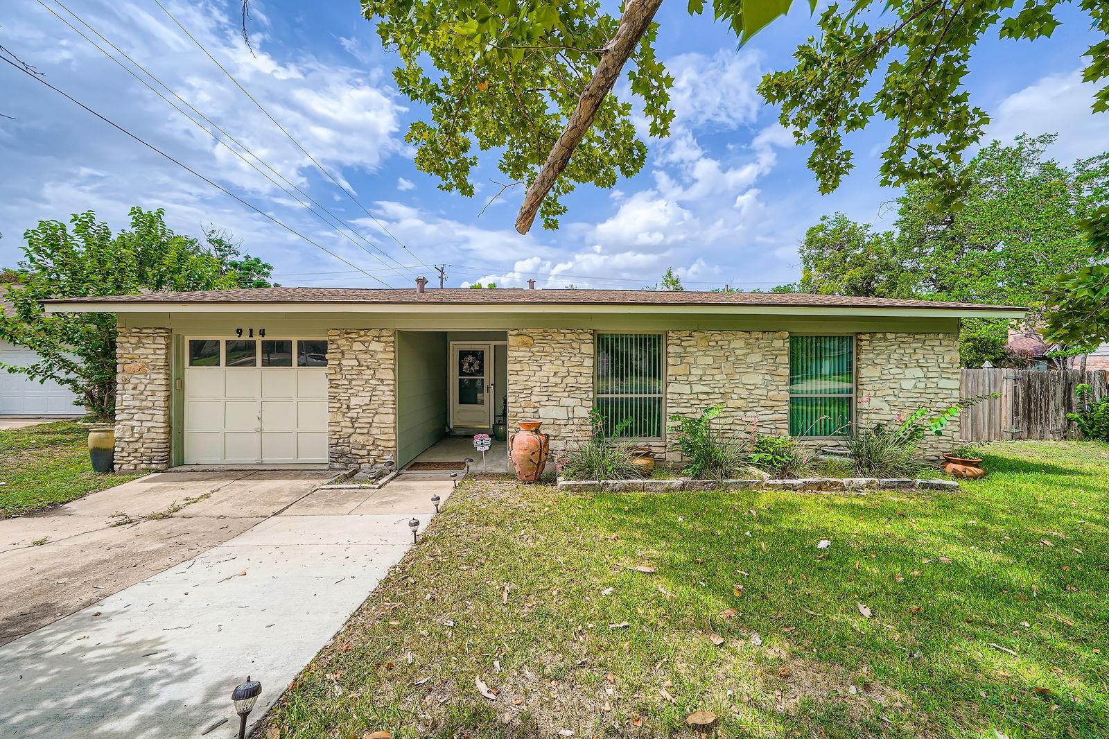 Single story home featuring stone siding, an atta