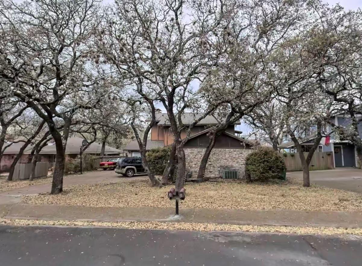 Obstructed view of property featuring stone sidin