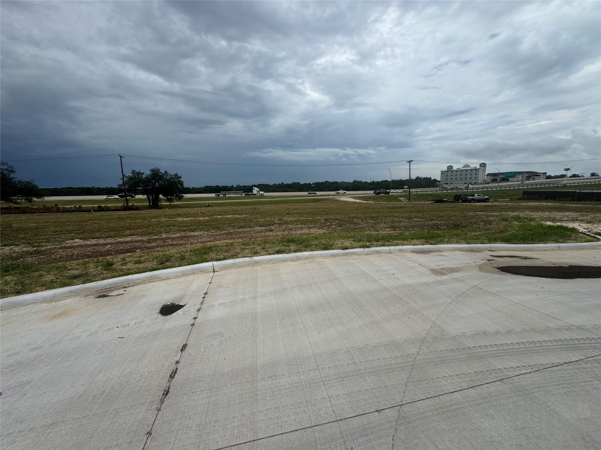 View of concrete road featuring curbs