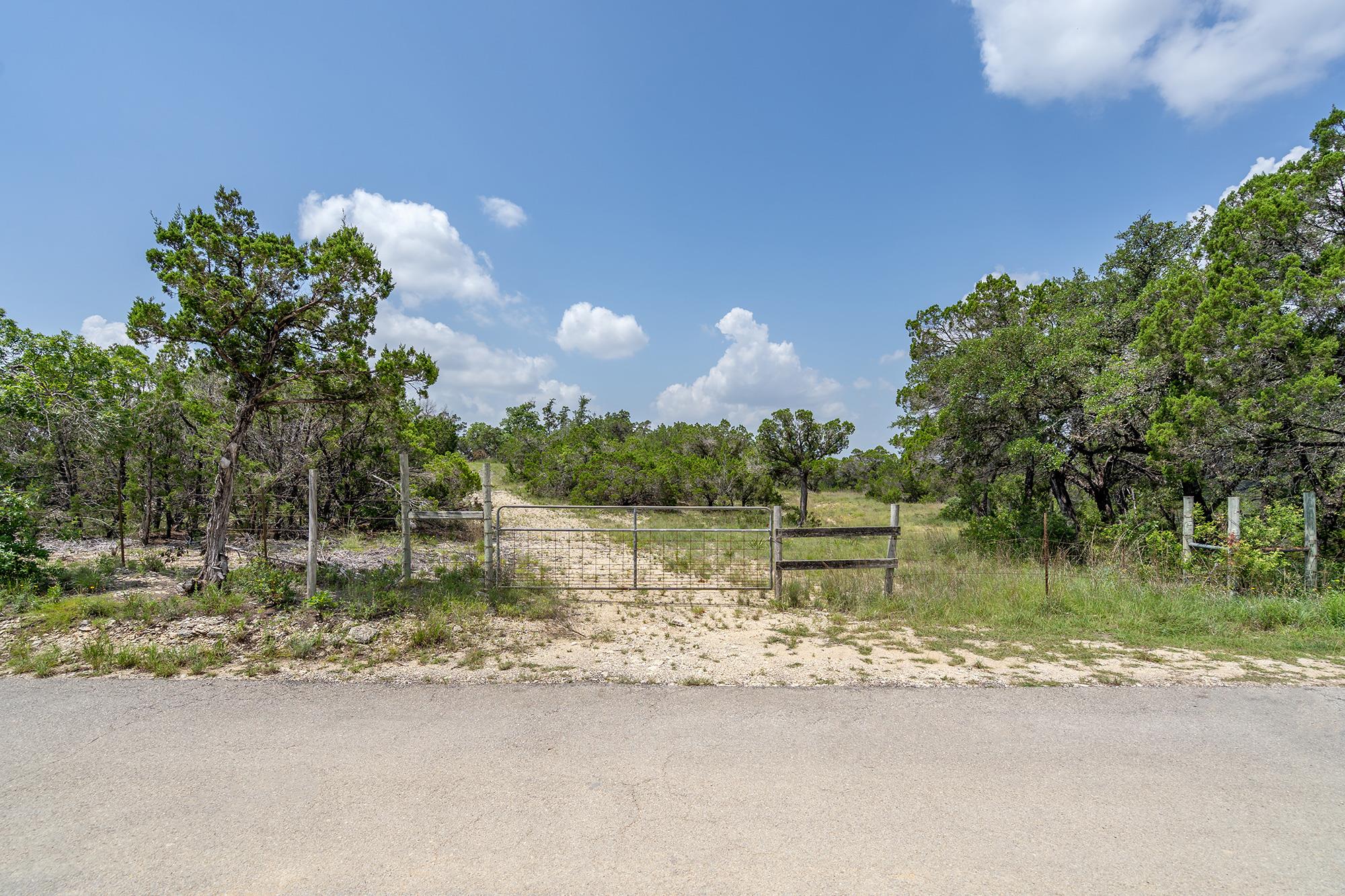 View of asphalt road featuring a gate