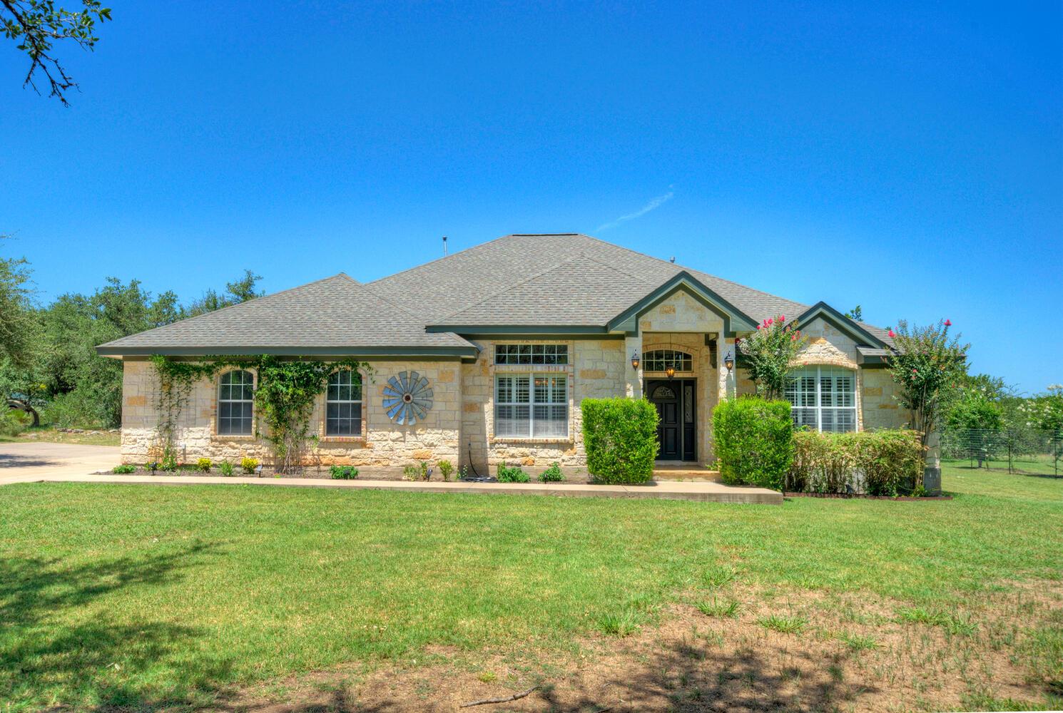 View of front facade with stone siding, a front y