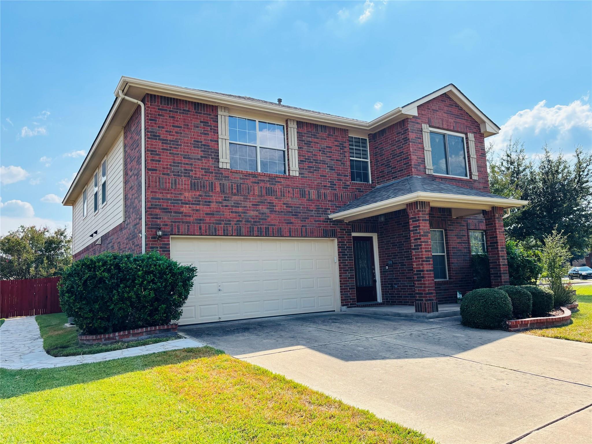 Traditional-style home with brick siding, drivewa