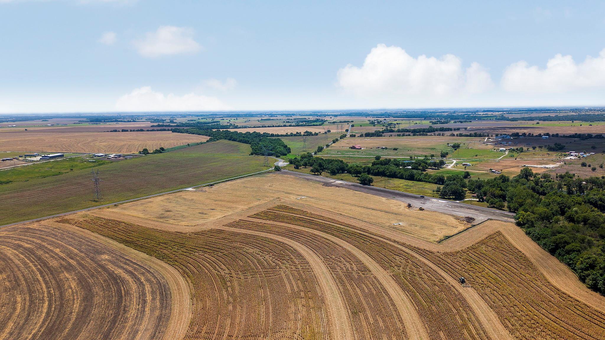 Vast agricultural acreage stretches toward the ho