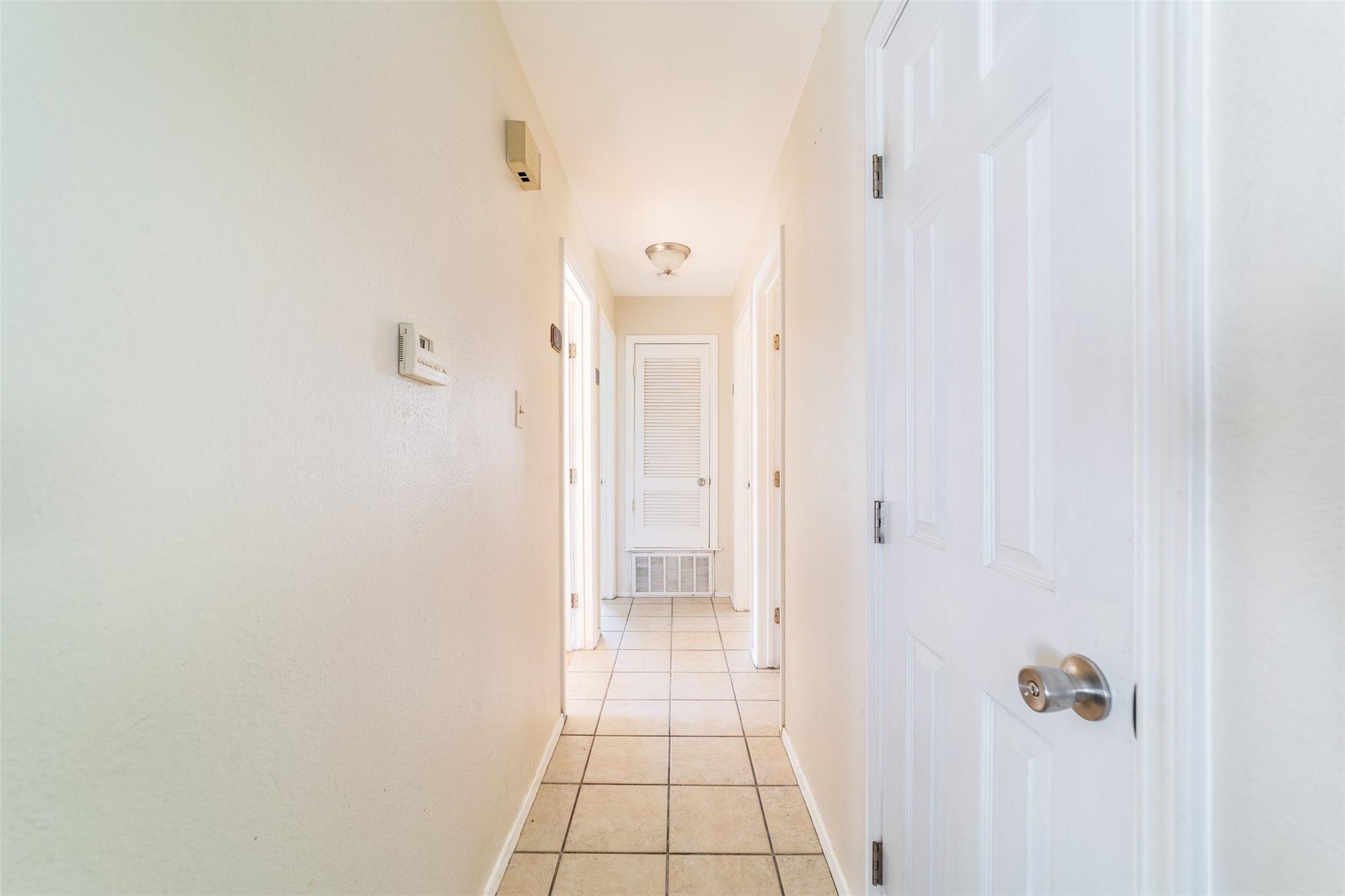 Hallway featuring light tile patterned flooring a