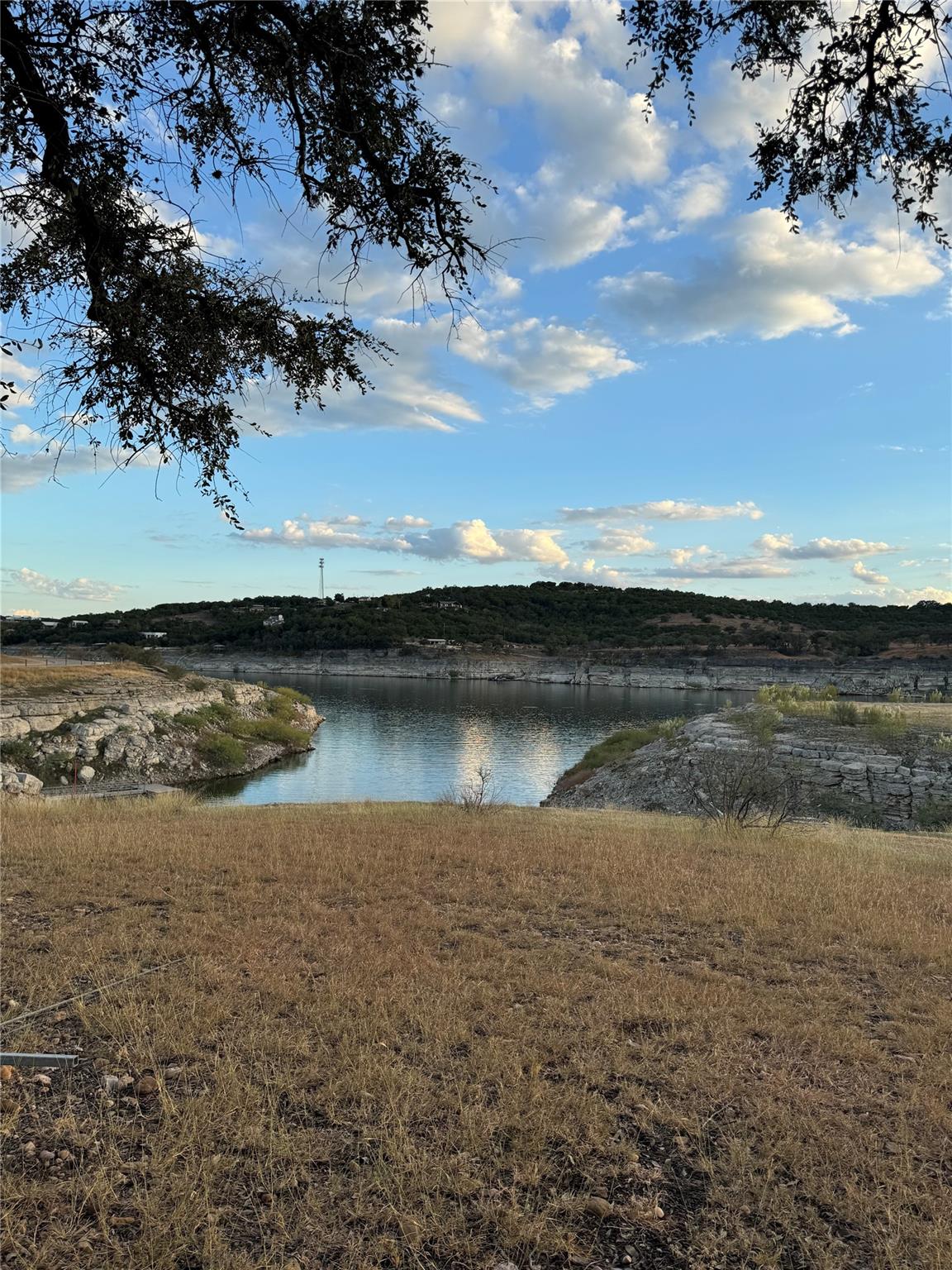 A tranquil lake view unfolds, framed by distant h