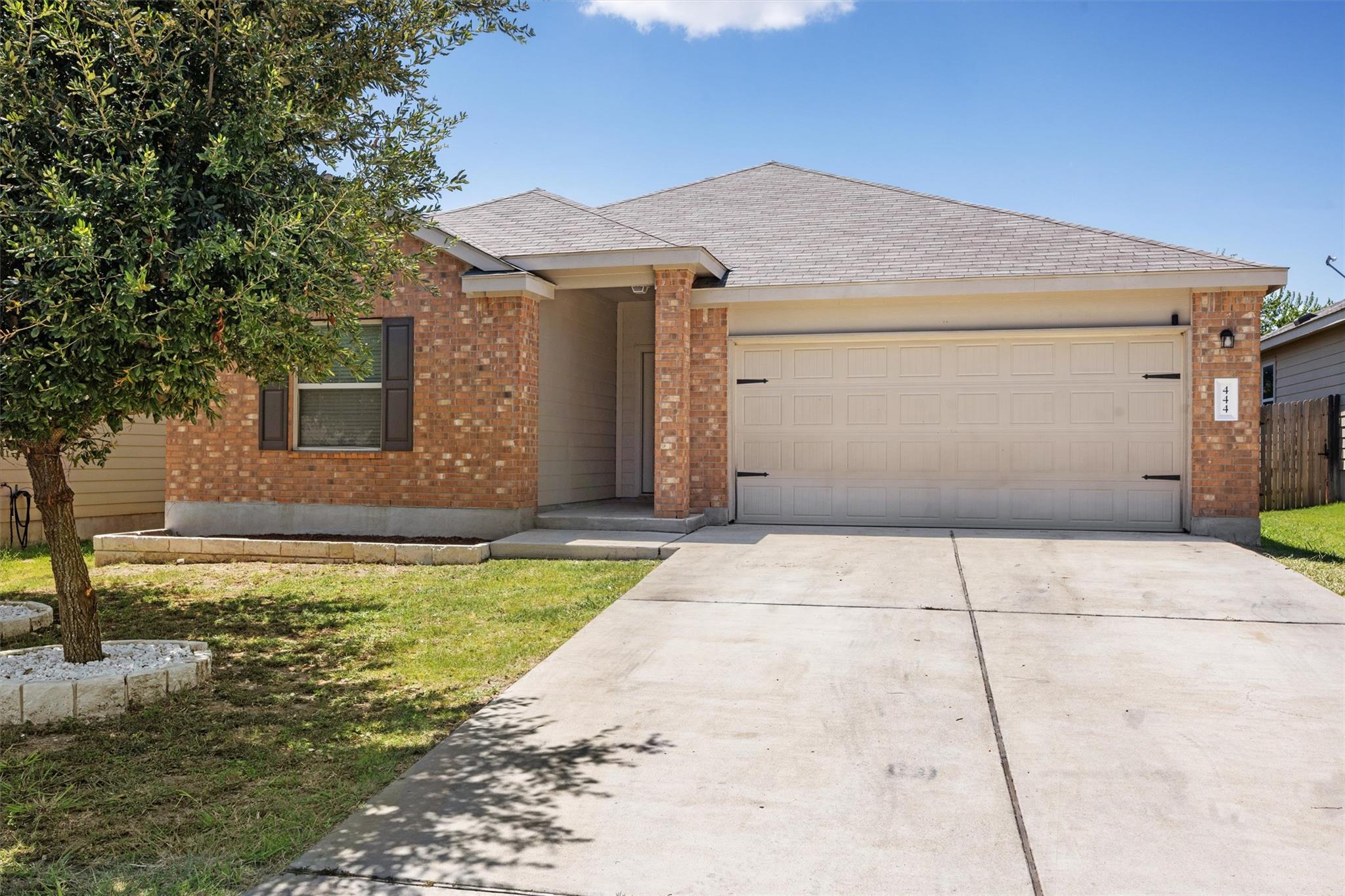 Ranch-style home with a garage, a shingled roof, 