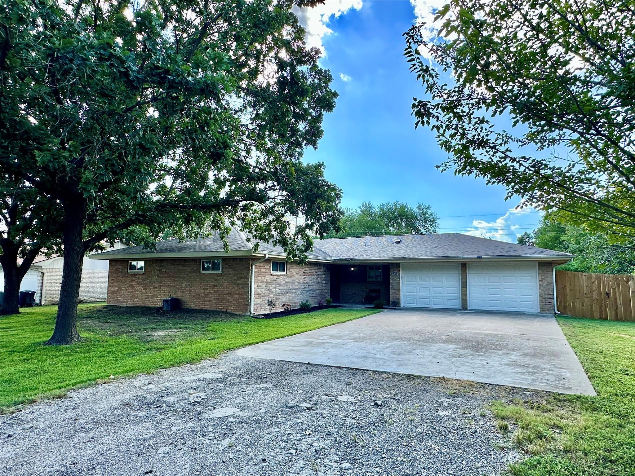 Single story home with gravel driveway, a garage,