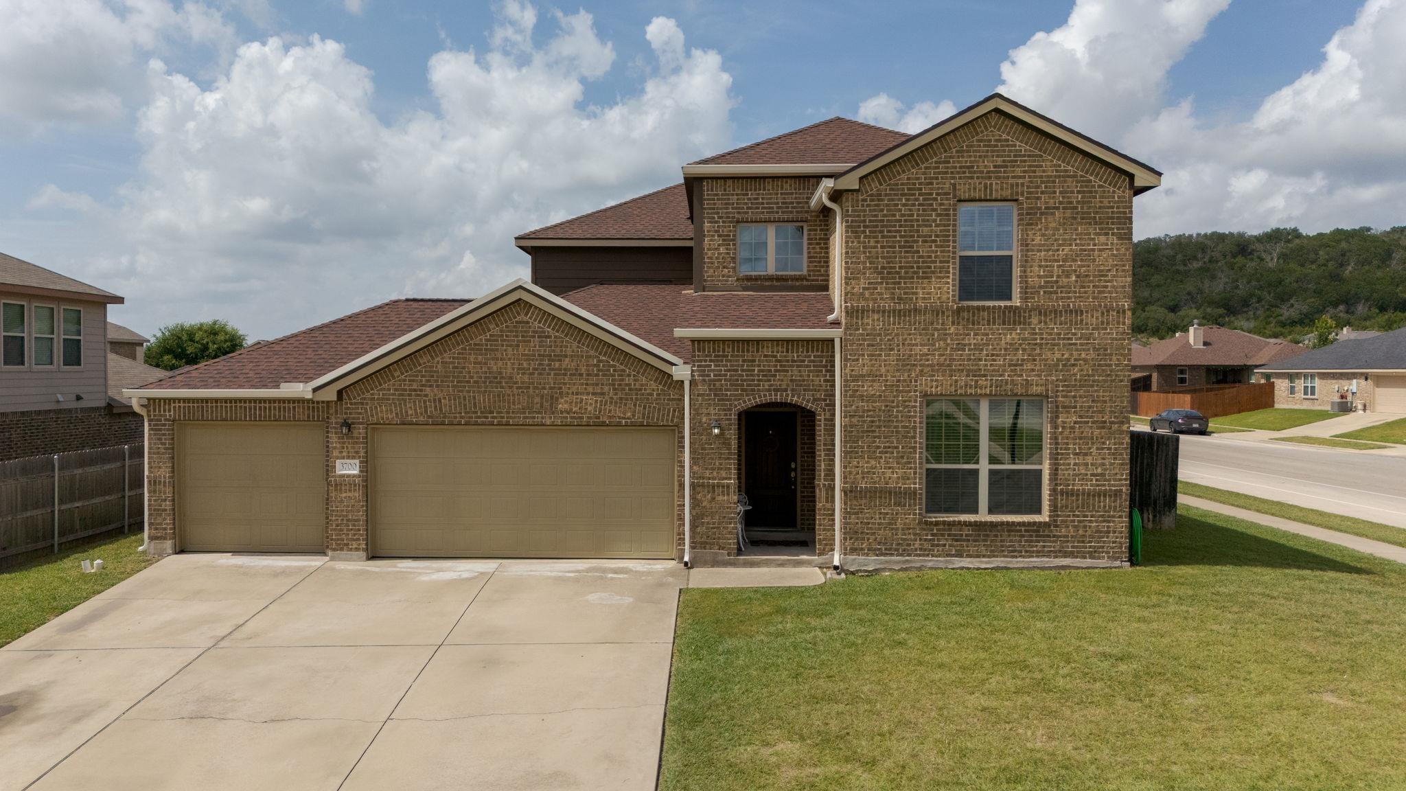 Traditional home featuring brick siding, a garage