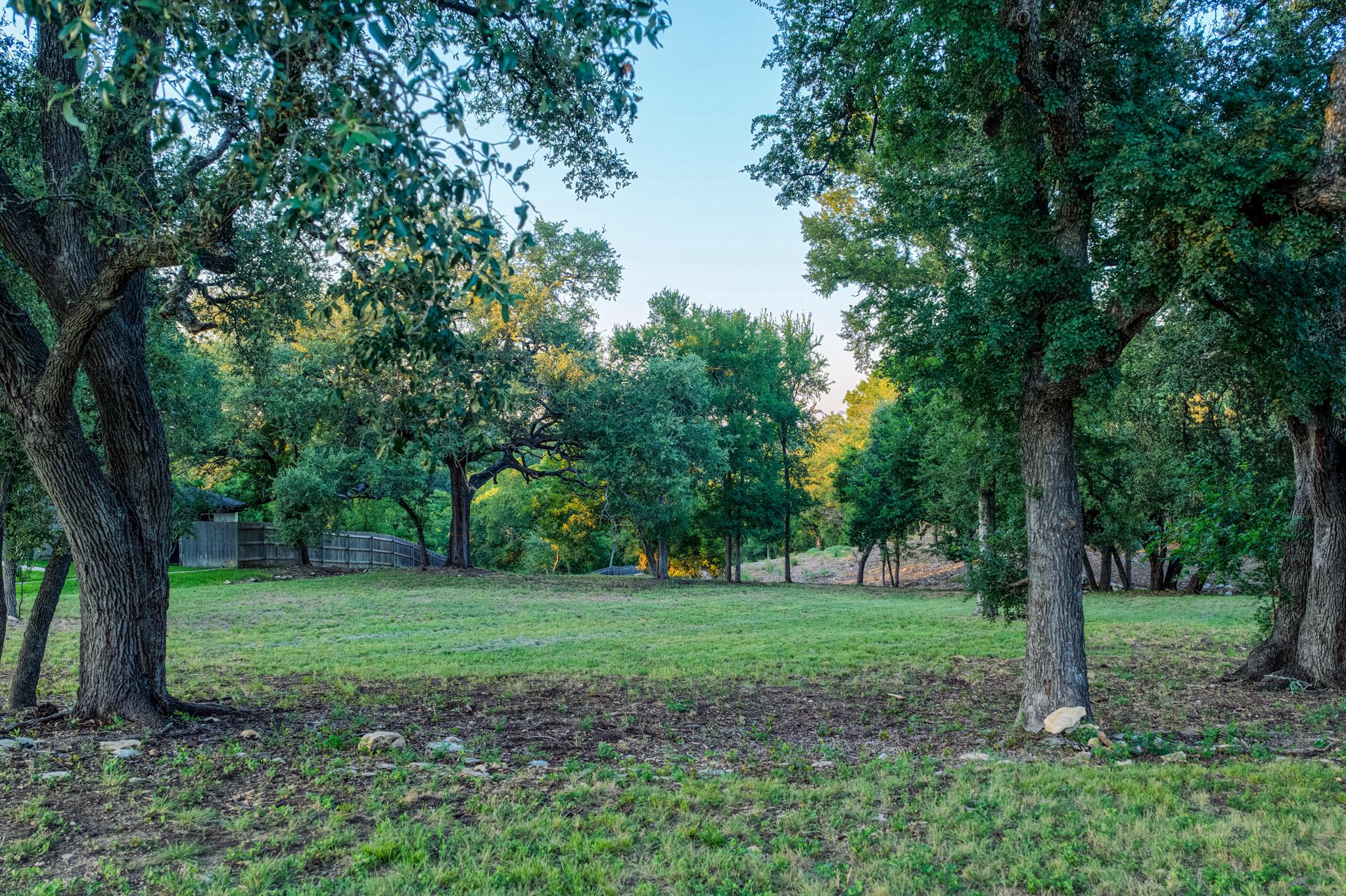 Mature trees frame a verdant, expansive lot, offe