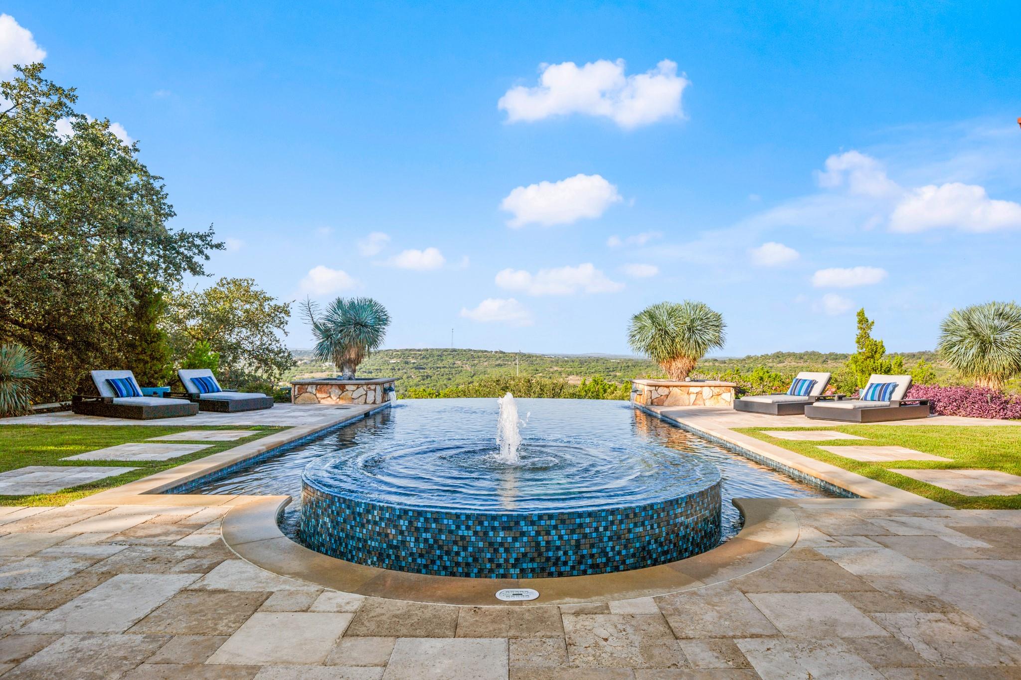 View of pool with an infinity pool and a patio