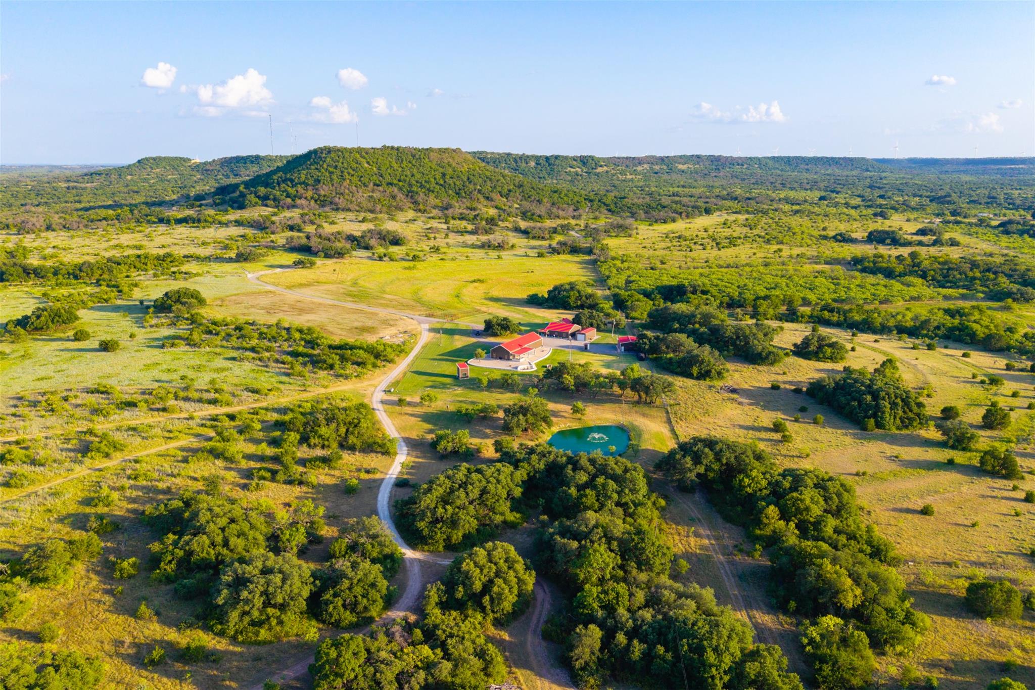 Rolling green pastures and a private pond surroun