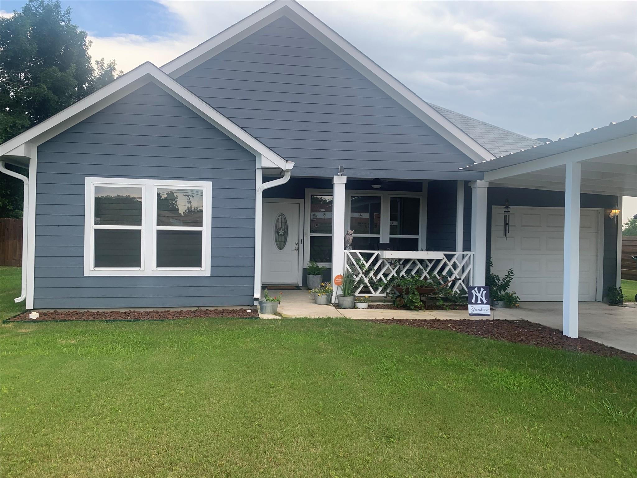 View of front of home with a front yard, a porch,