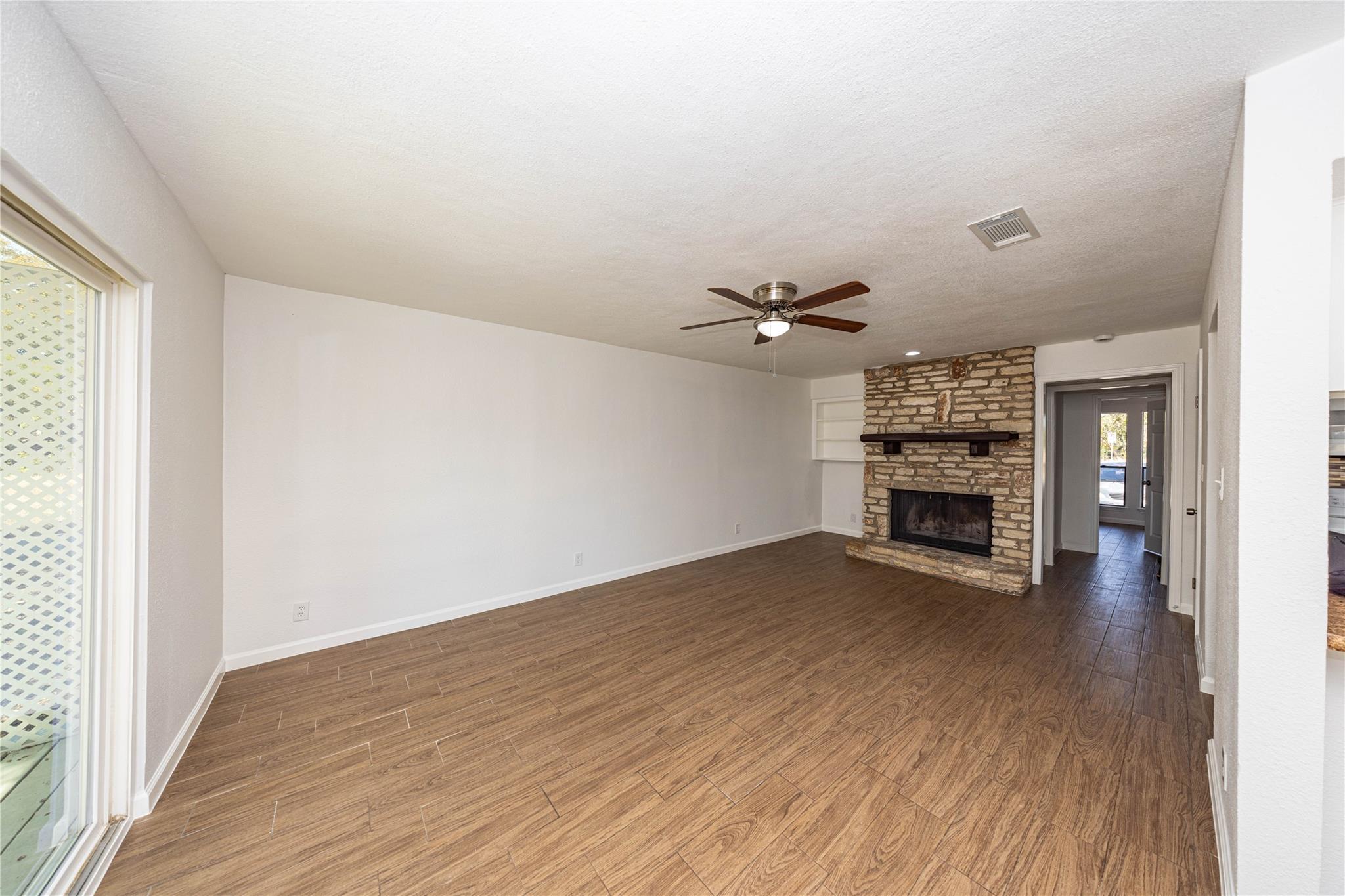 Unfurnished living room featuring wood finished f
