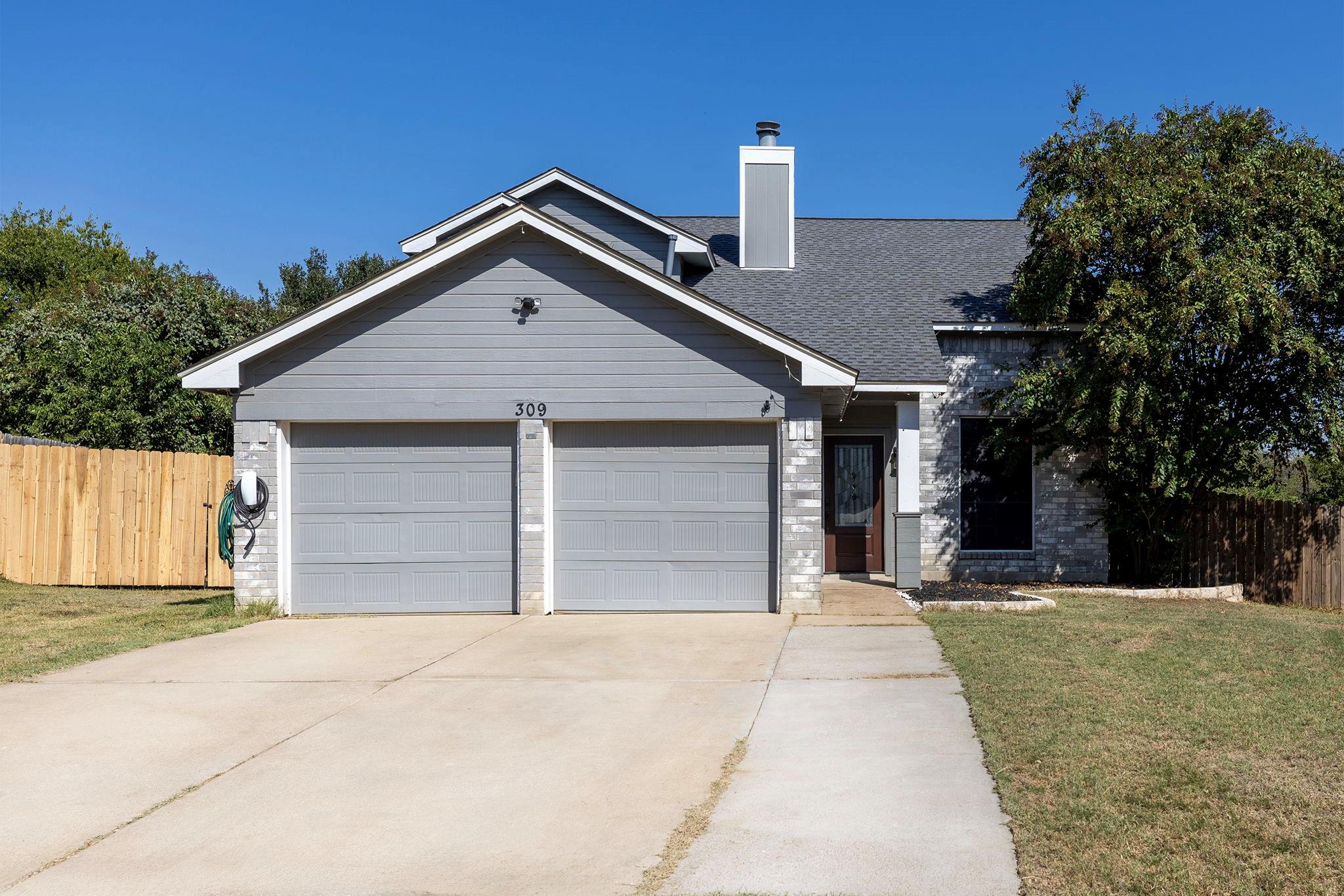 View of front of home with a chimney, concrete dr