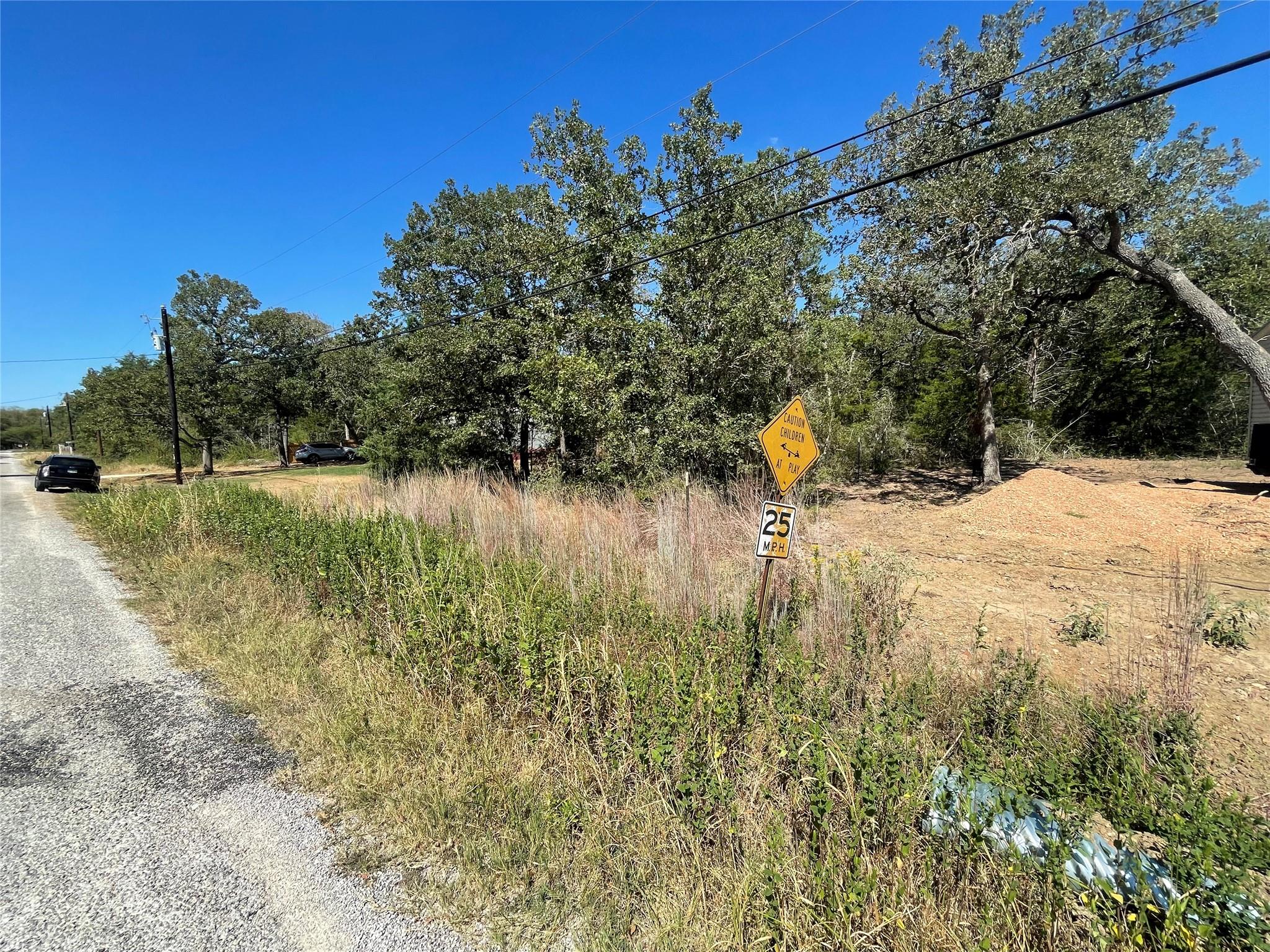 View of dirt / gravel road featuring traffic signs