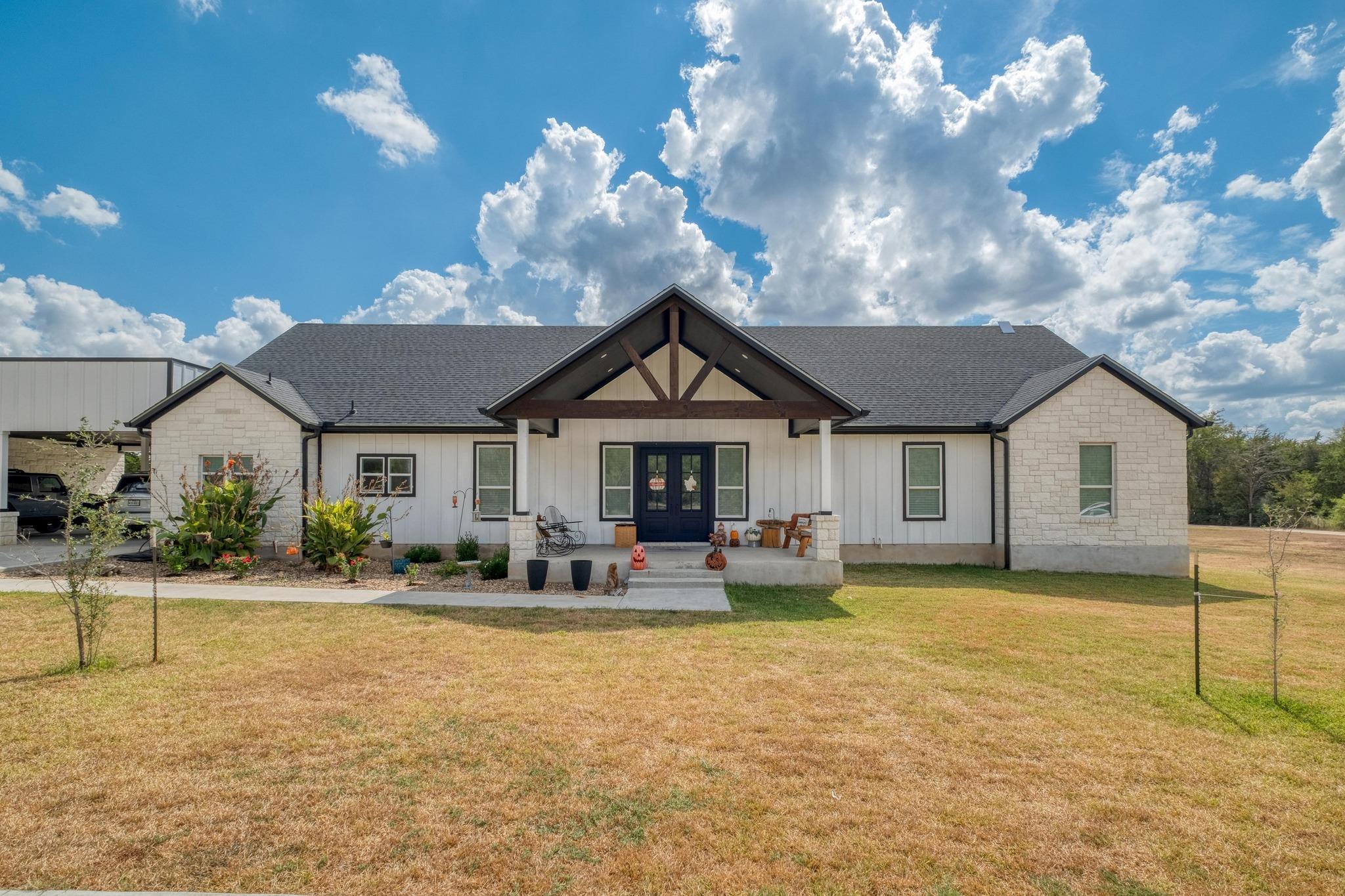 View of front of property with a porch, a front y
