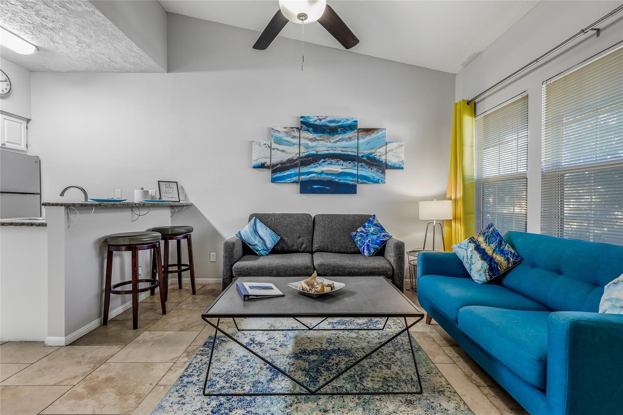 Living room with lofted ceiling, ceiling fan, and
